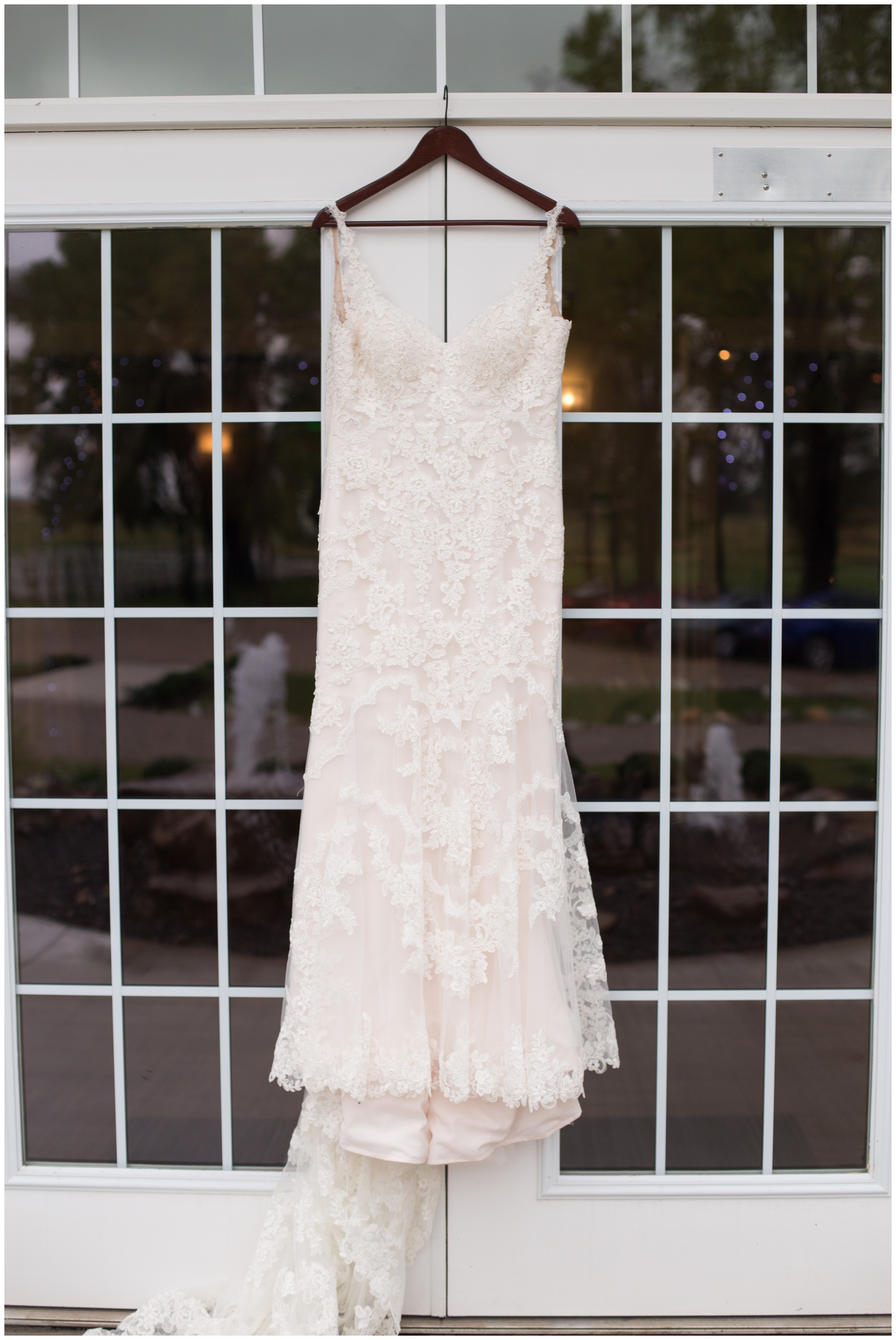 bride's wedding dress hanging on doors at The Lodge at River Valley Farm in Yorktown Indiana