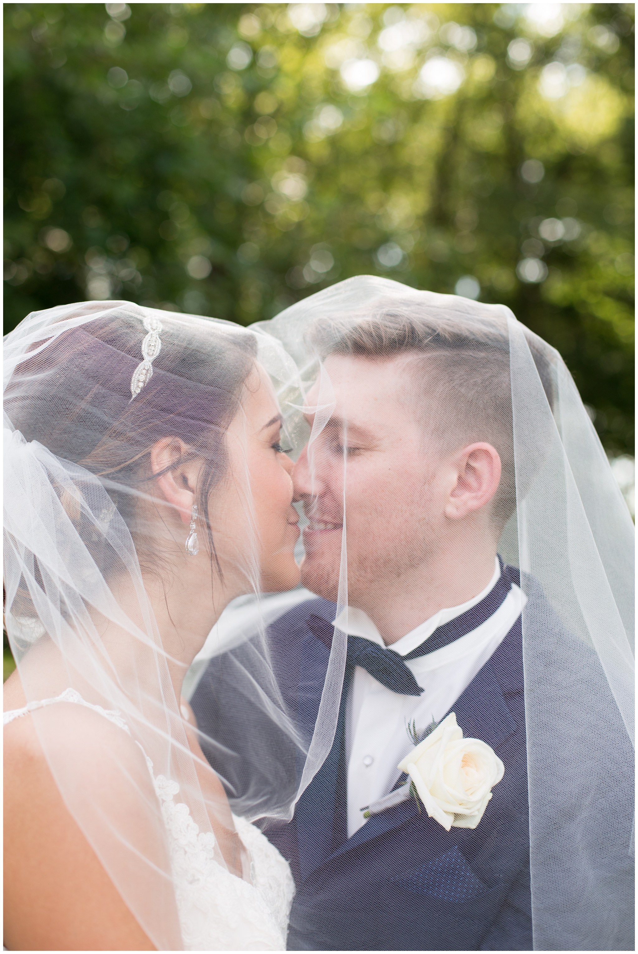 bride and groom under veil during portraits at the Lodge at River Valley Farm in Yorktown Indiana