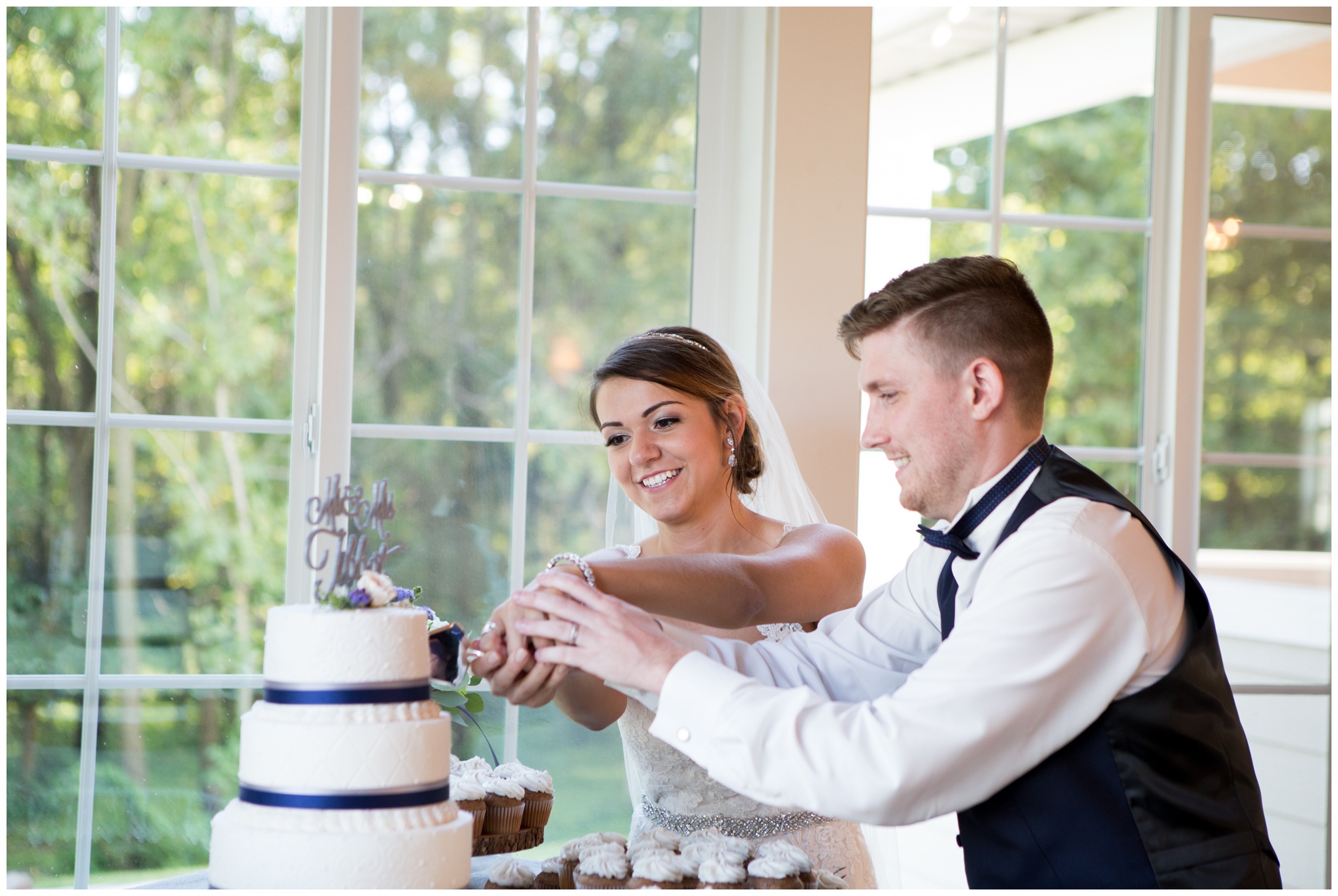 bride and groom cut cake during reception at the Lodge at River Valley Farm in Yorktown Indiana