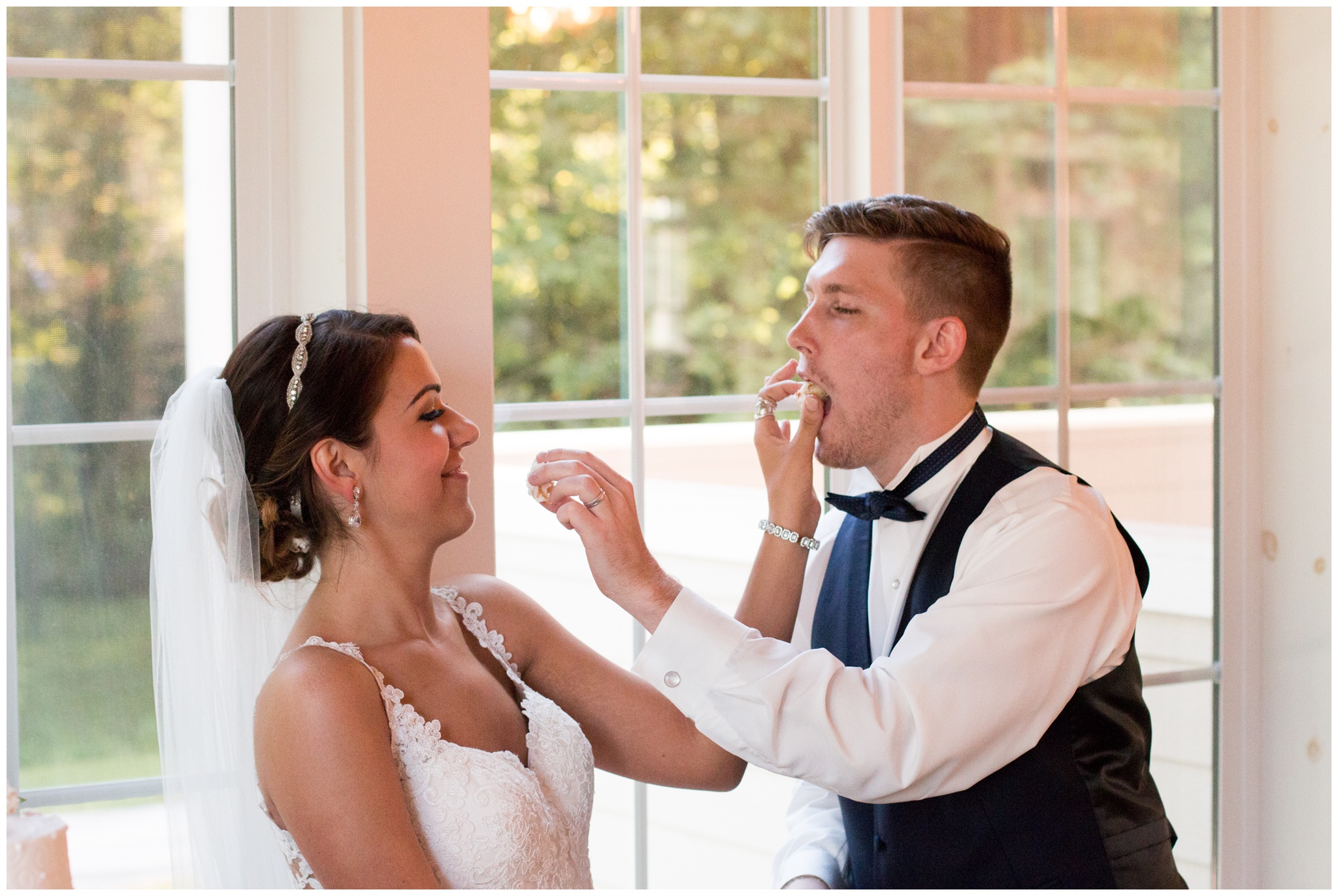 bride and groom feed each other cake during reception at the Lodge at River Valley Farm in Yorktown Indiana