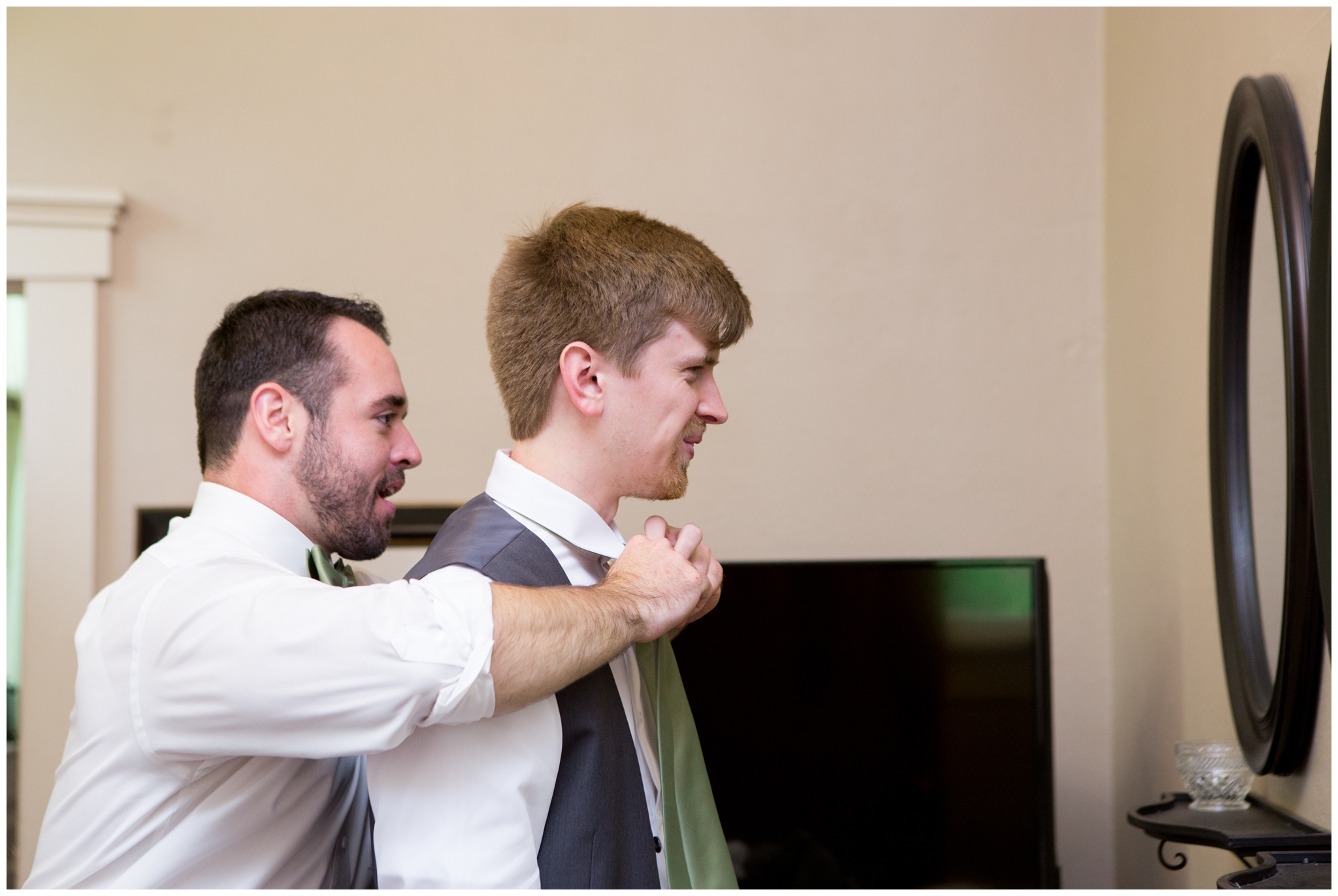 groomsman putting on groom's tie before ceremony at Historic Meeting House at New Garden in Fountain City, Indiana