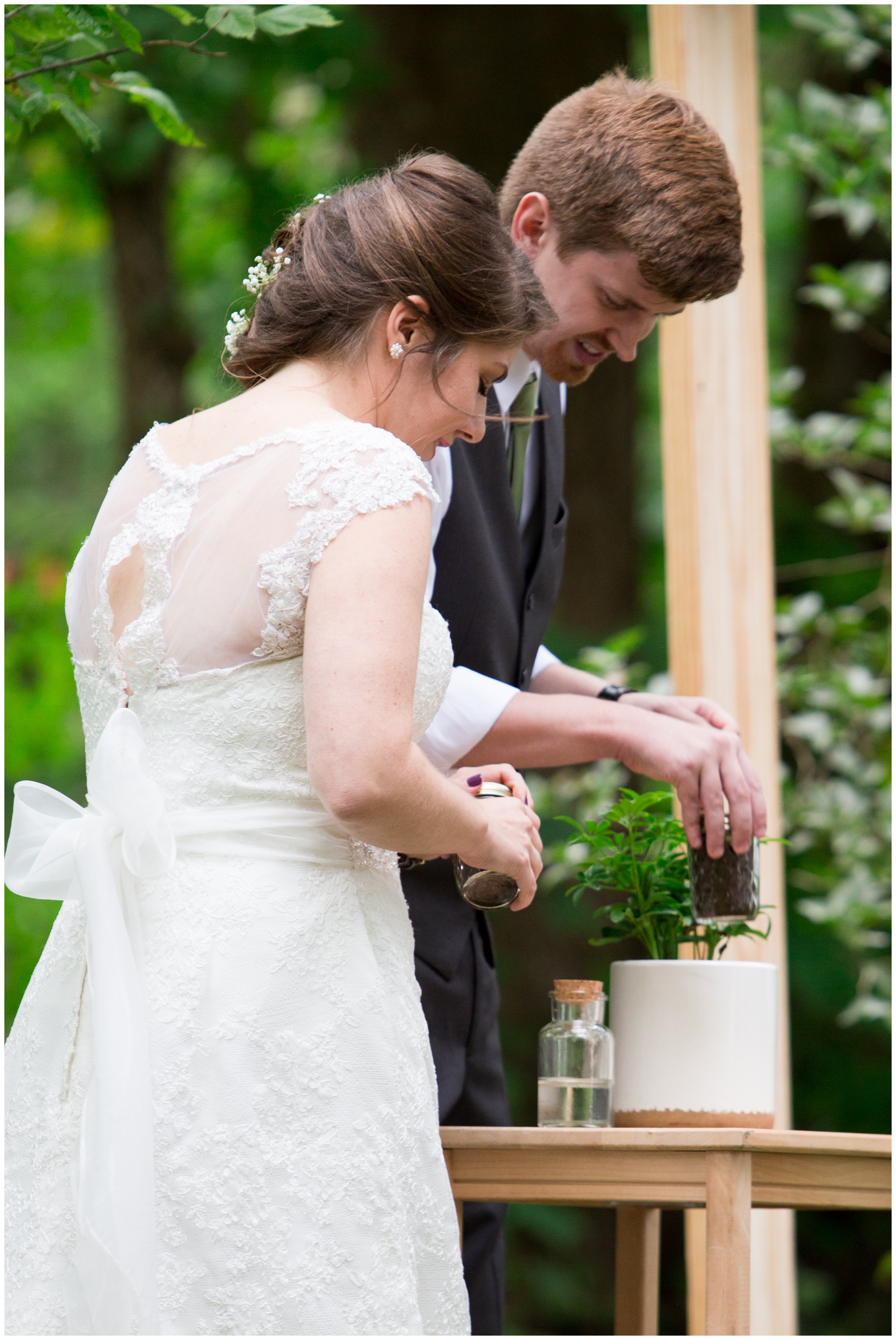 bride and groom putting soil into unity plant during ceremony at Historic Meeting House at New Garden in Fountain City Indiana