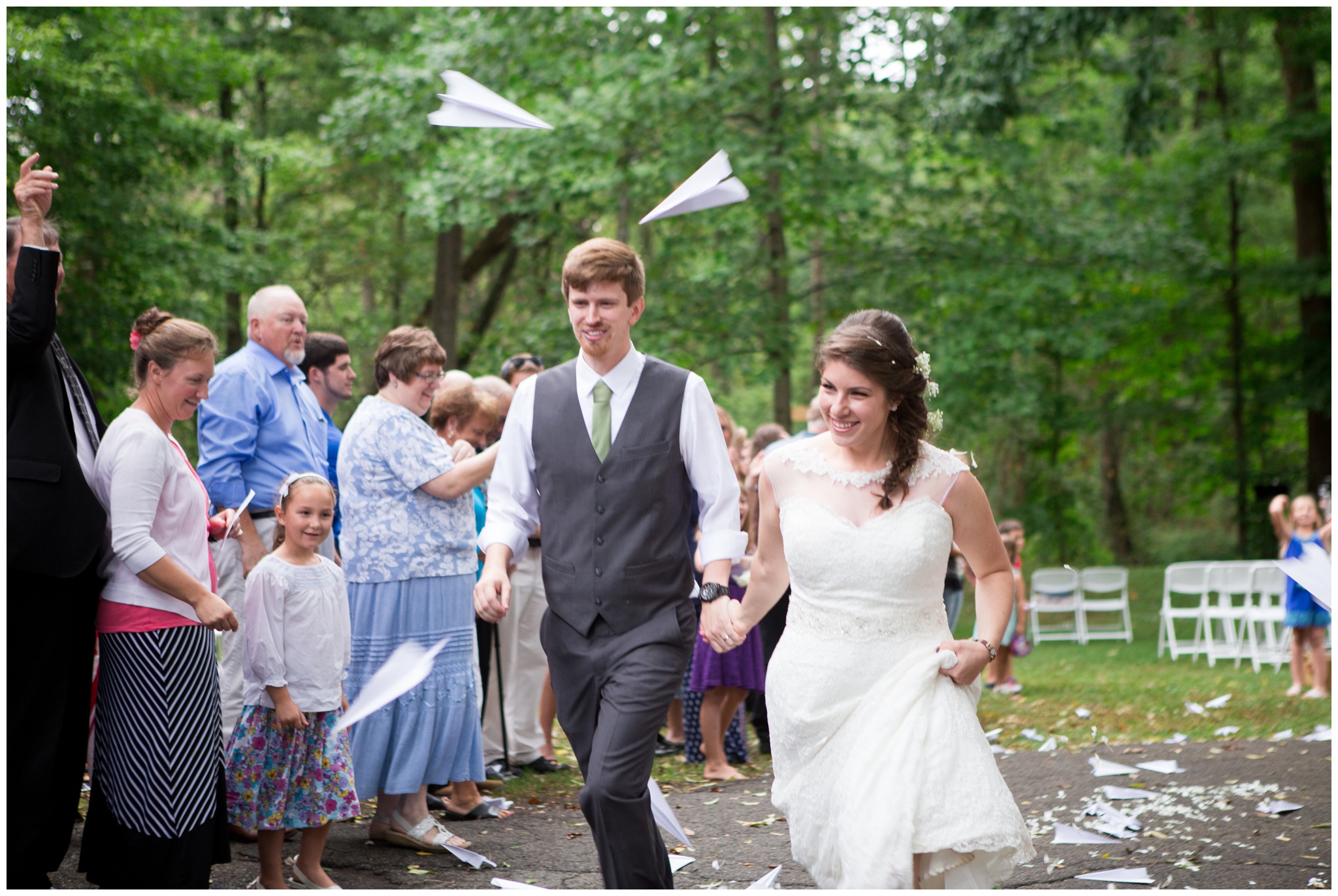 bride and groom exit ceremony under paper airplanes at Historic Meeting House at New Garden in Fountain City Indiana