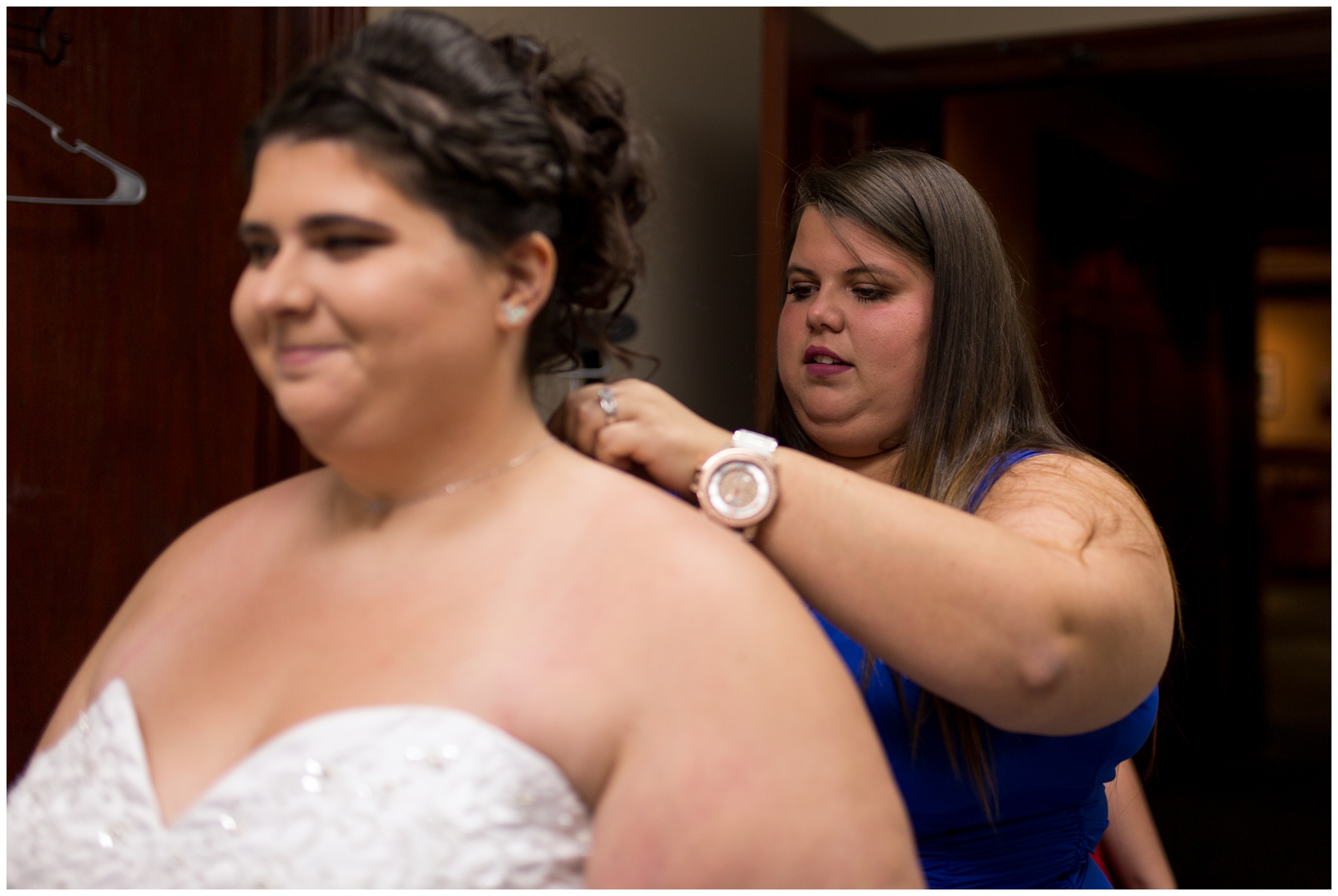 maid of honor putting on bride's necklace before Community Life Center wedding in Indianapolis Indiana