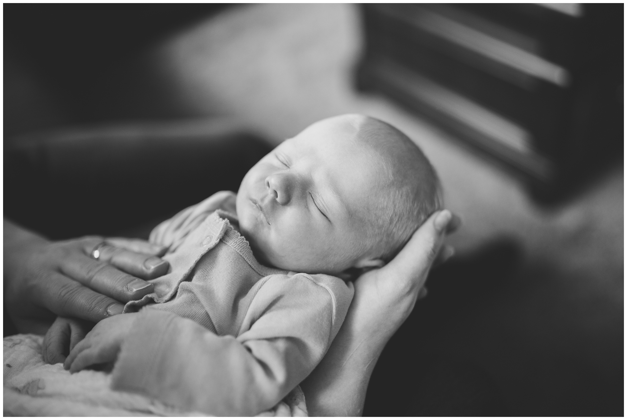 mom and dad holding baby in hands during Indianapolis newborn photography session
