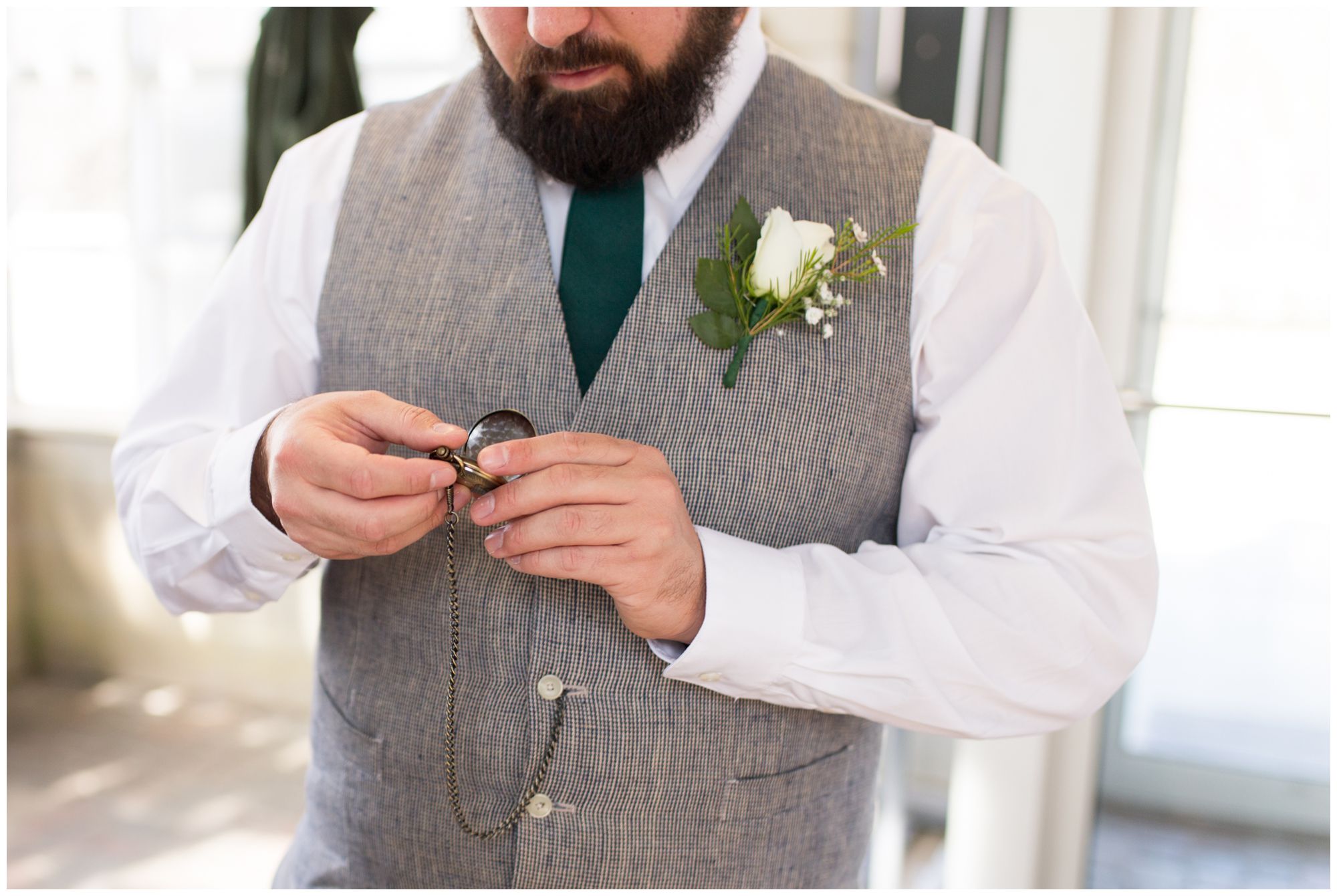 groom looks at pocket watch before wedding at Garfield Park Conservatory wedding