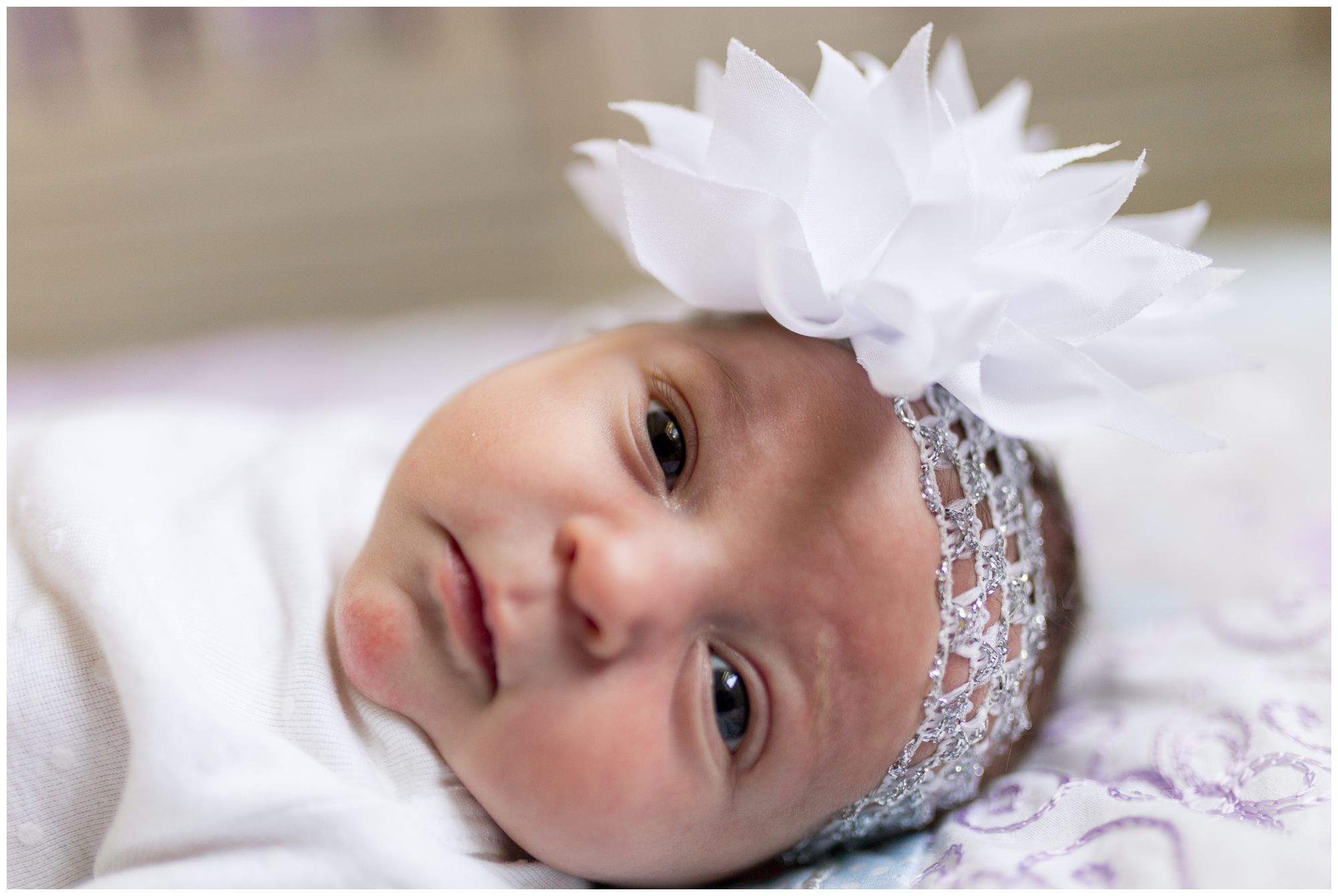 up close of newborn's face with flower headband in Kokomo Indiana