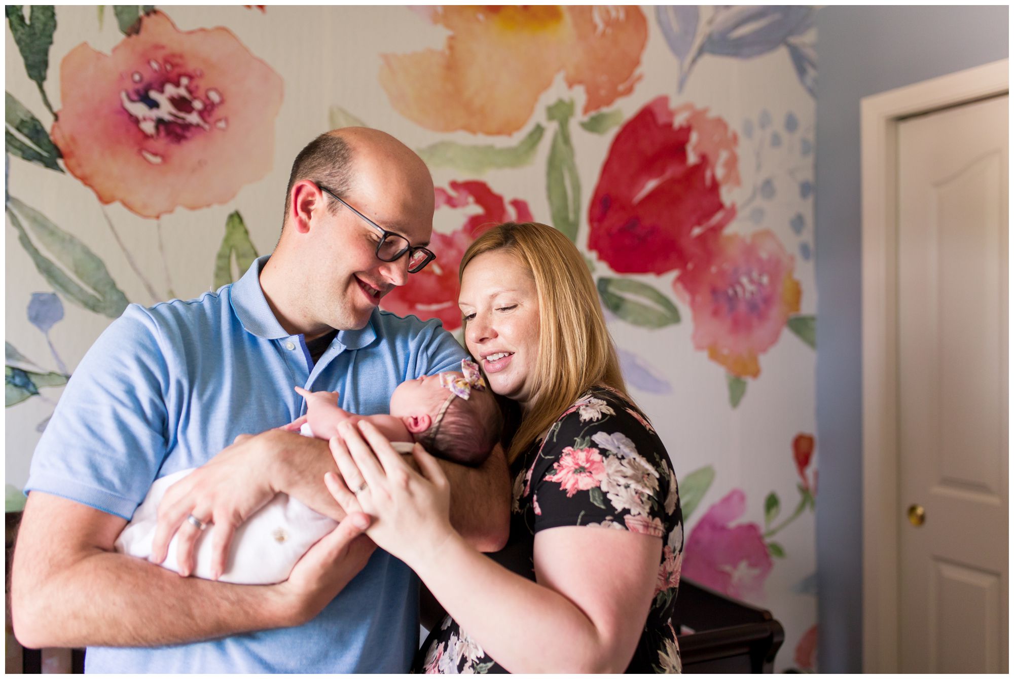 Westfield newborn photographer photographs mom and dad holding newborn baby in nursery