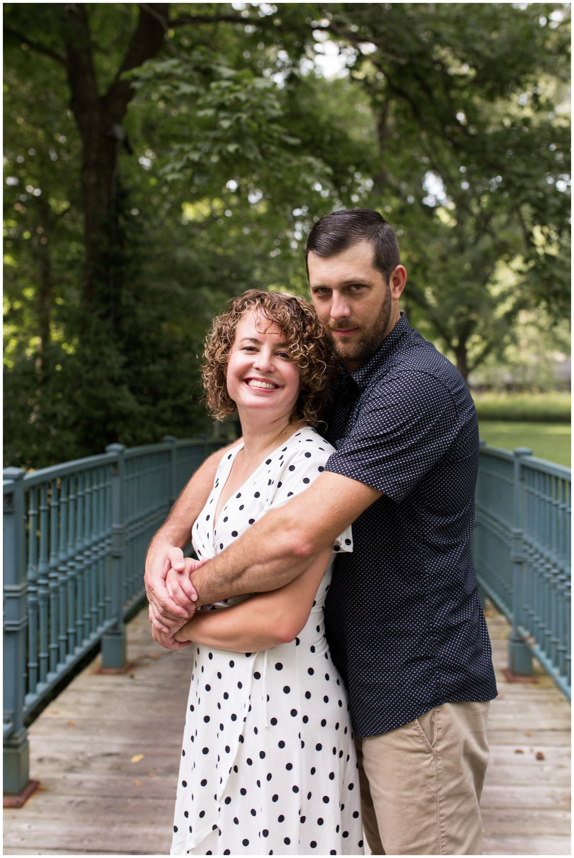 groom wraps bride in arms during Wabash Indiana engagement session at Charley Creek Gardens