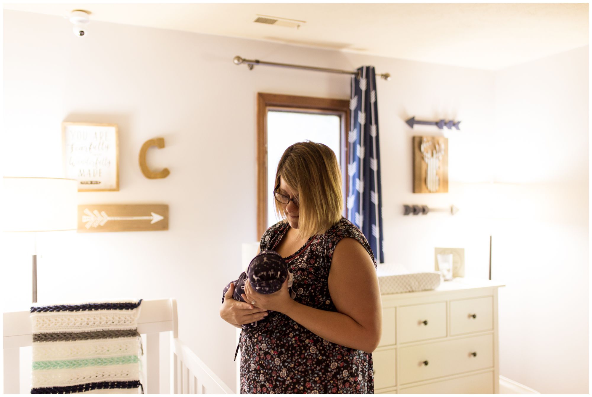 Kokomo newborn photographer captures mom holding newborn in nursery
