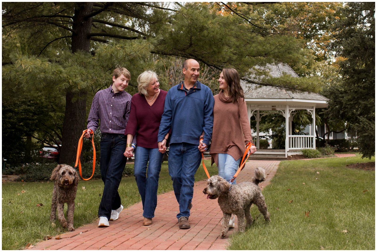 family walks dogs together during downtown Zionsville family session