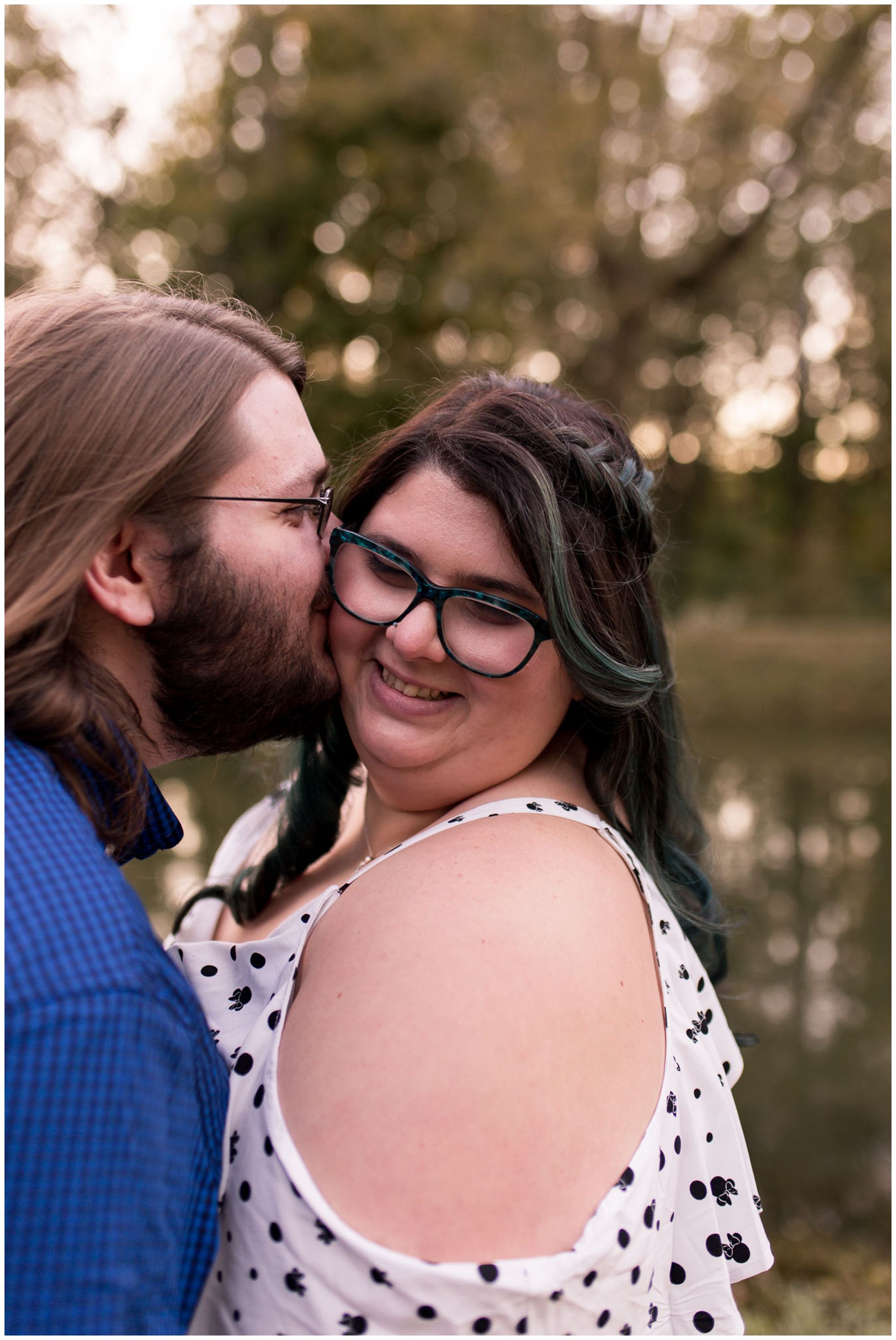 wife smiles as husband kisses cheek during Indianapolis anniversary session at Holcomb Gardens
