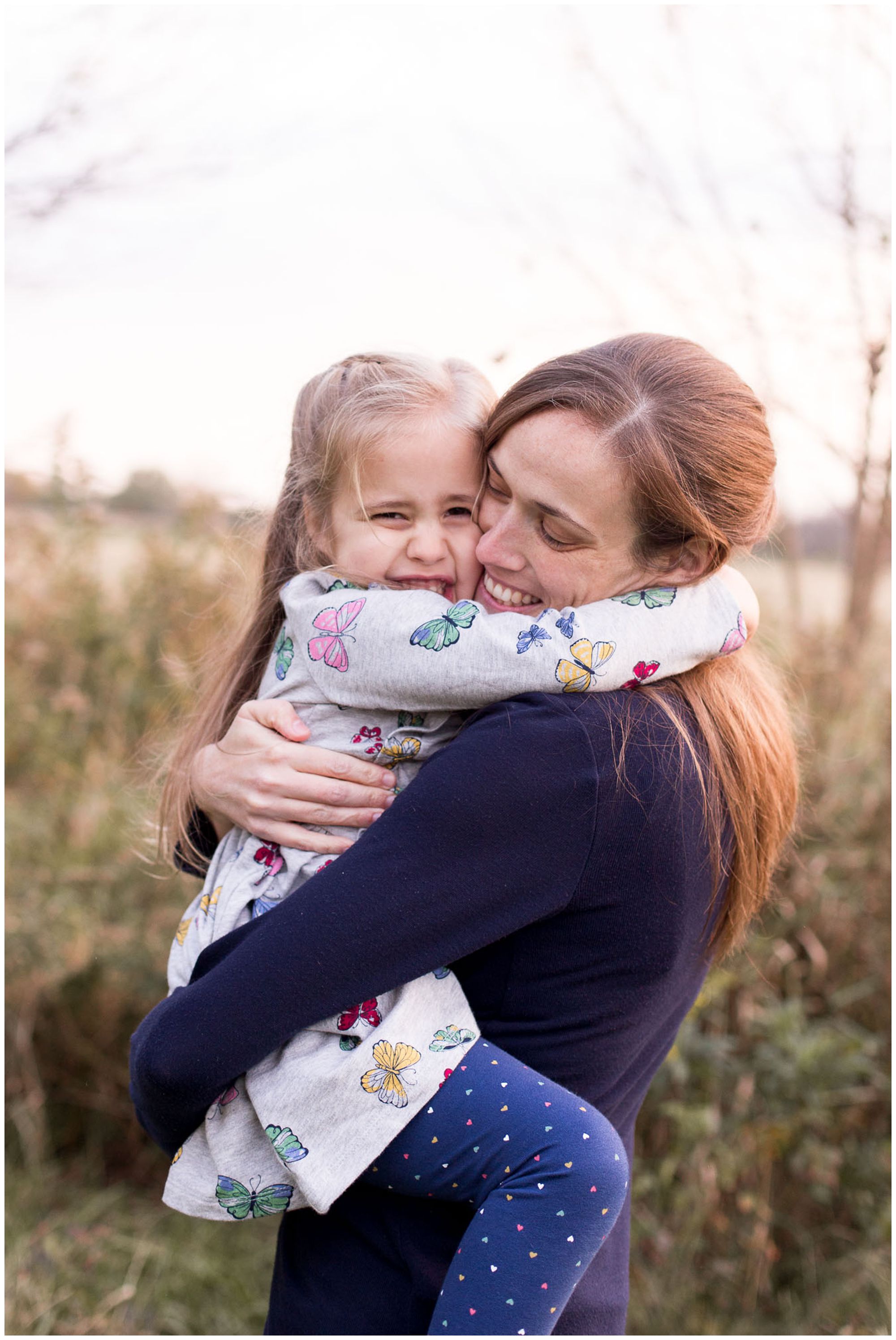 mom snuggles daughter during family session in Kokomo Indiana