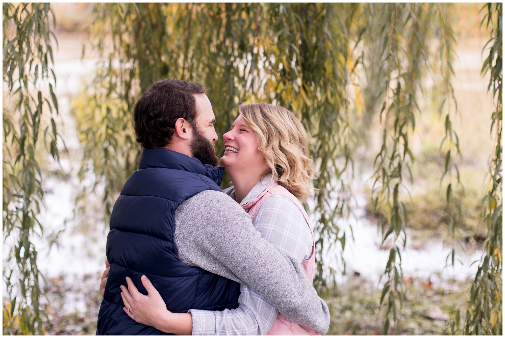 bride and groom sway during engagement session by willow tree in downtown Fort Wayne Indiana