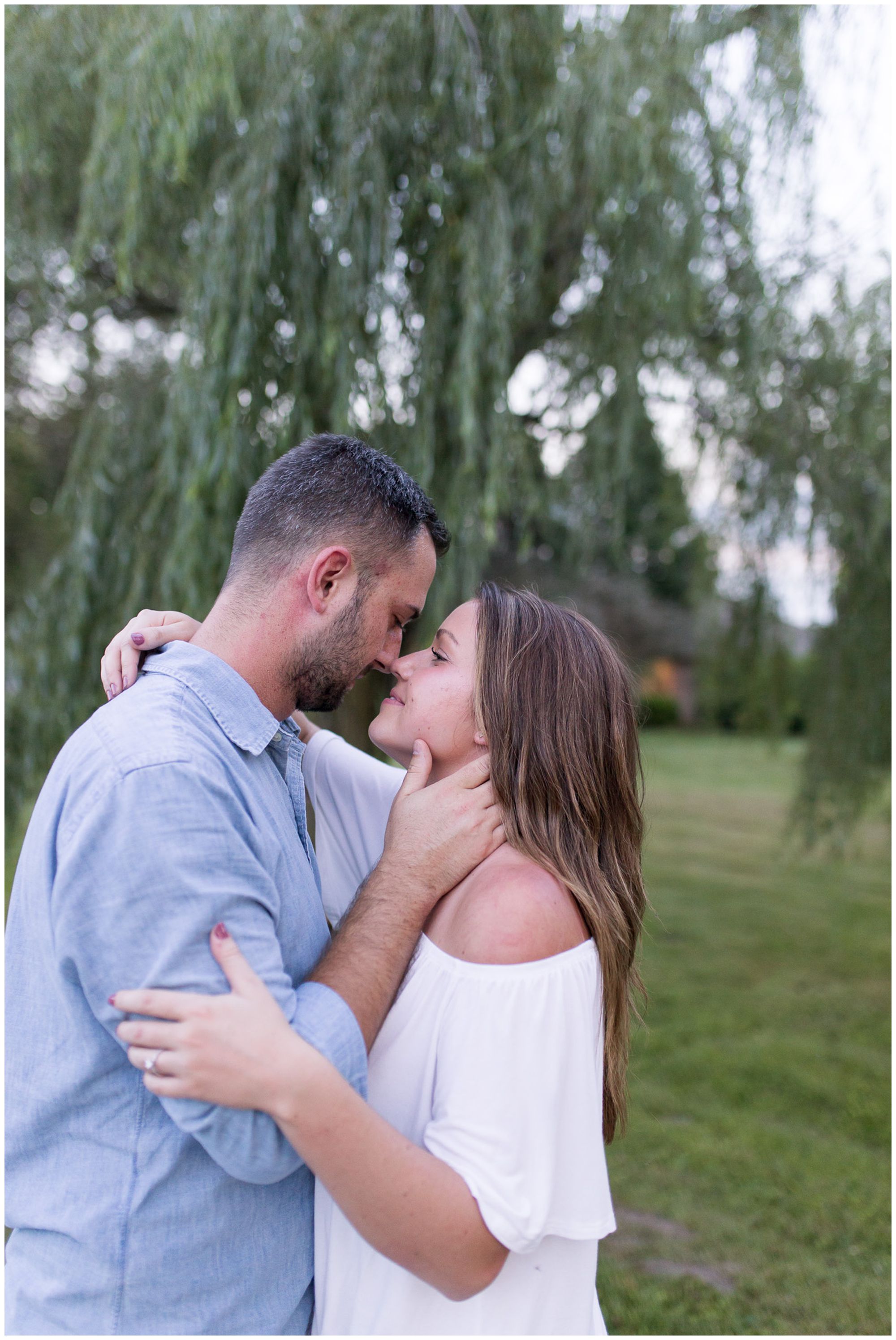 couple goes in for kiss during Fort Wayne engagement session at Metea County Park