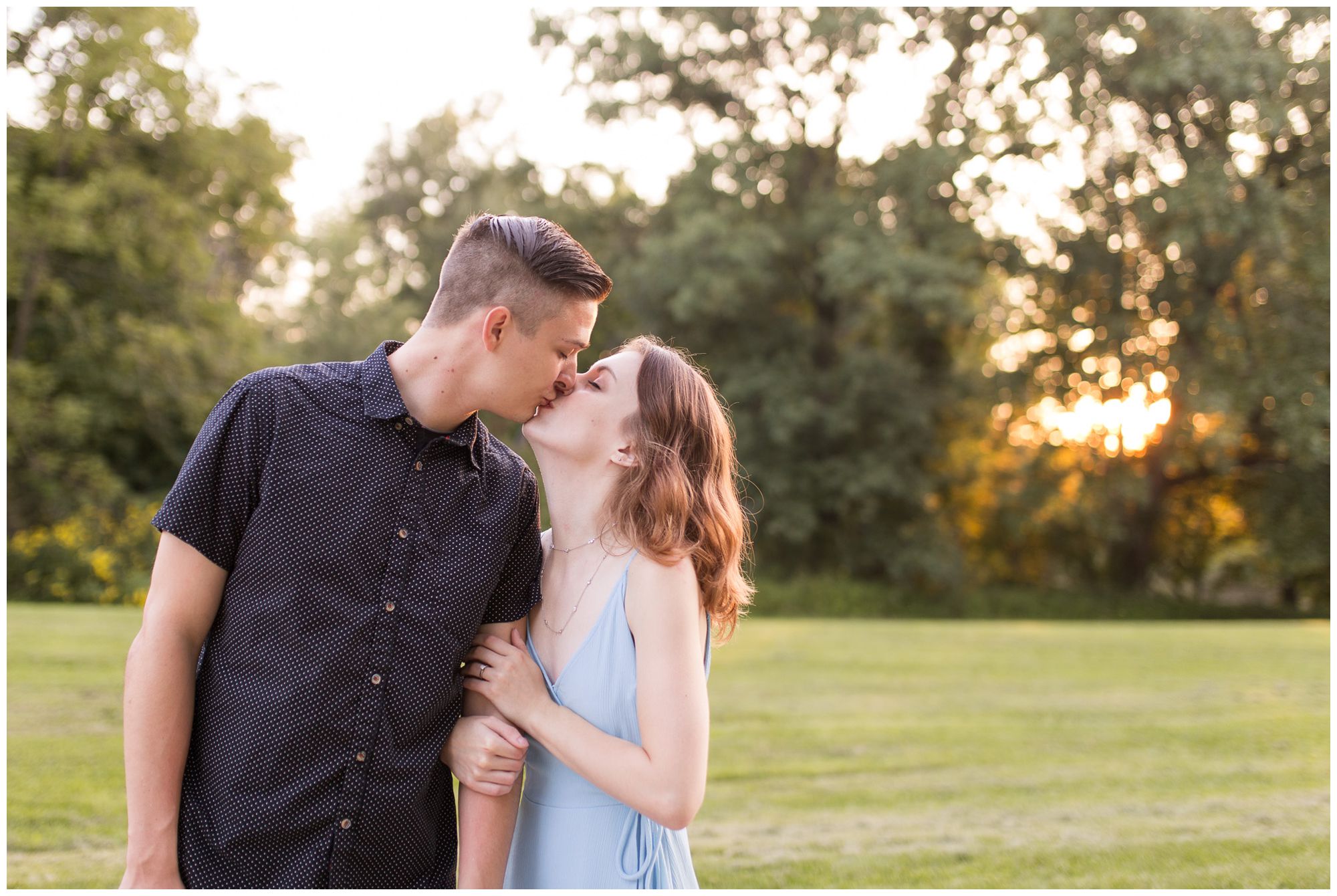 bride wraps arm in groom's and kisses him during Fort Wayne engagement session