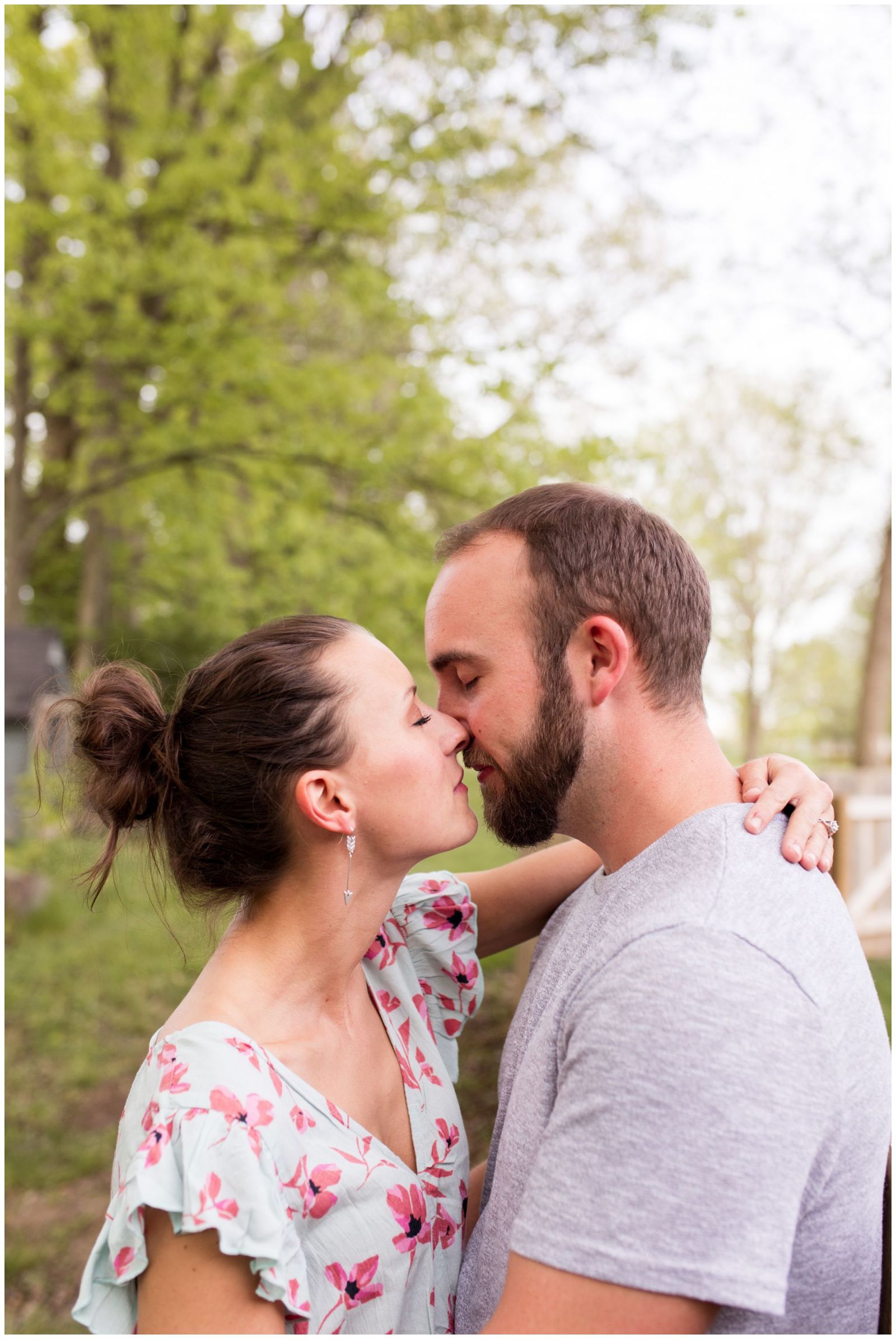 bride and groom kiss in horse pasture during Indianapolis engagement session