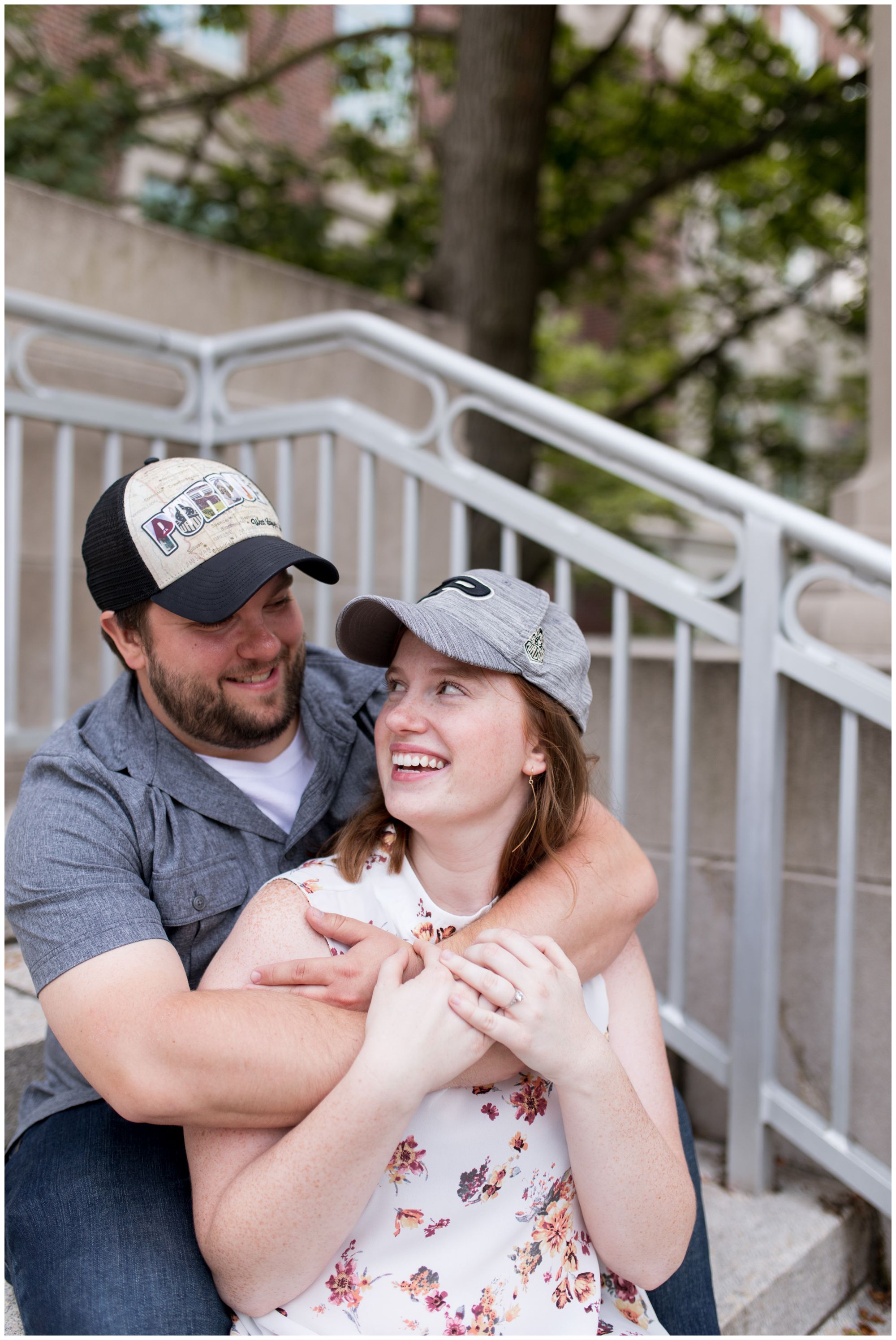 couple laughs in Purdue hats during West Lafayette Indiana engagement session