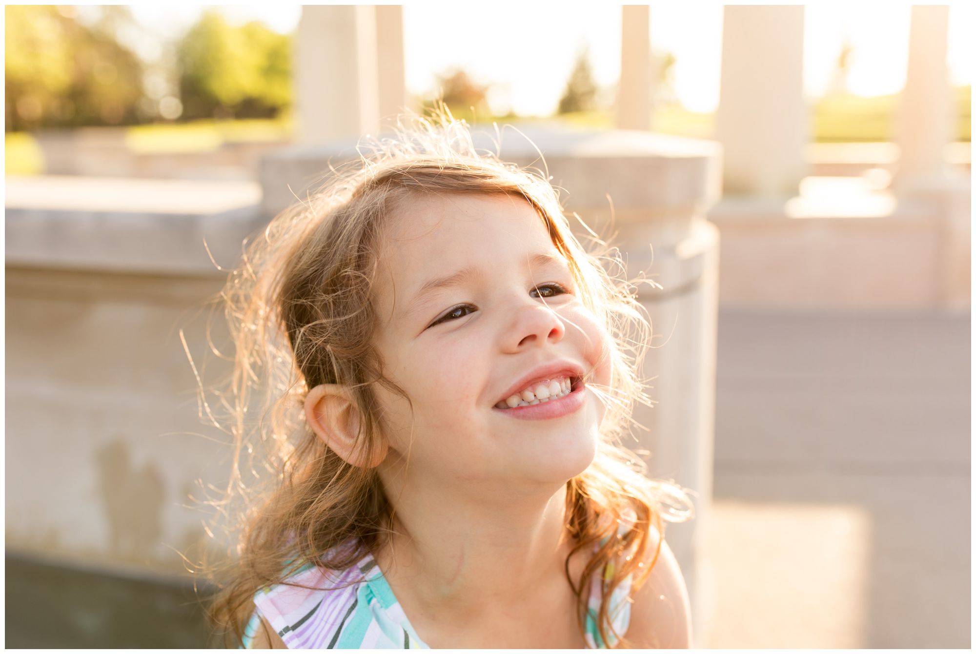 little girl smiling at camera at Coxhall Gardens during family session