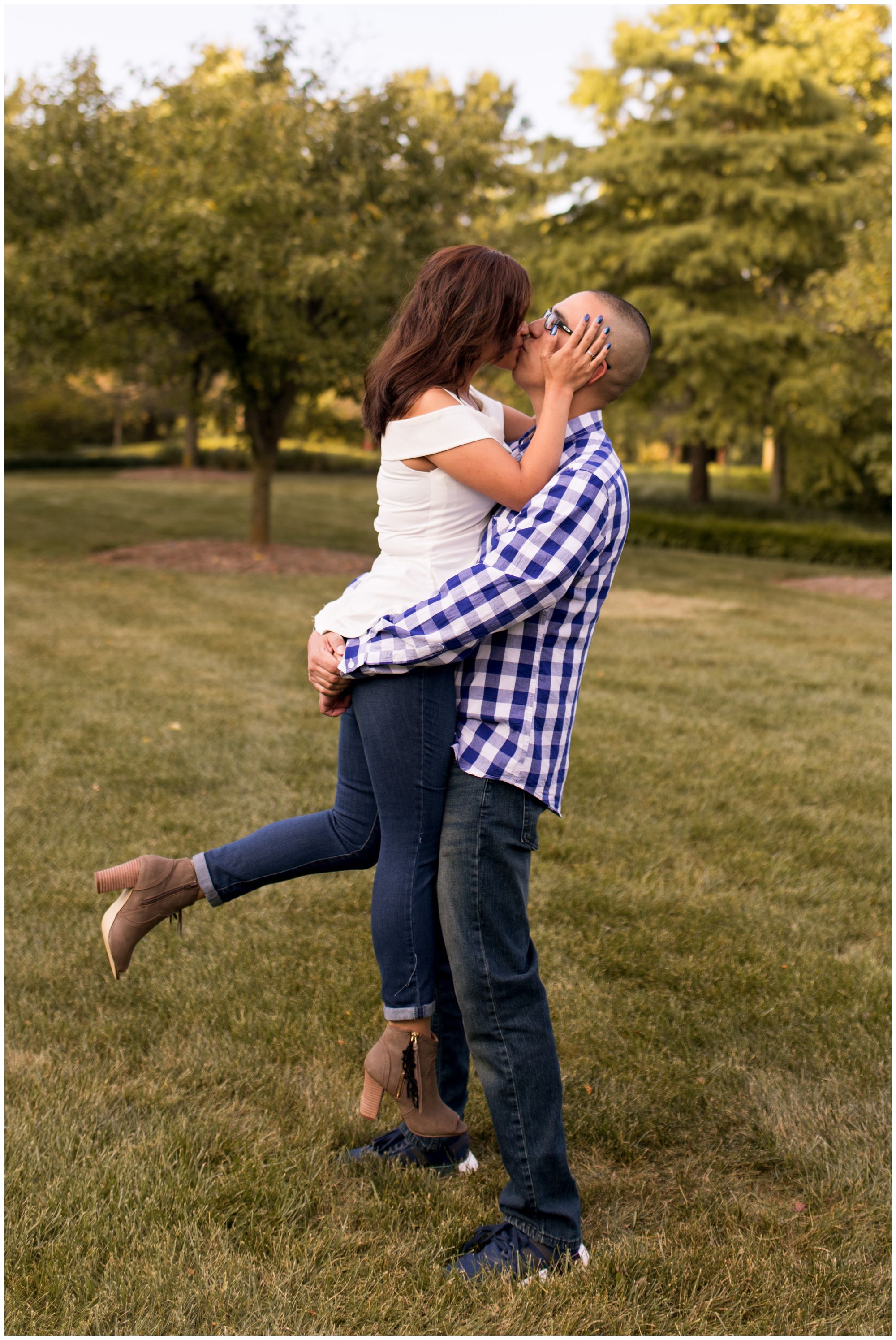 groom lifts bride during Fort Wayne engagement session at Headwaters Park