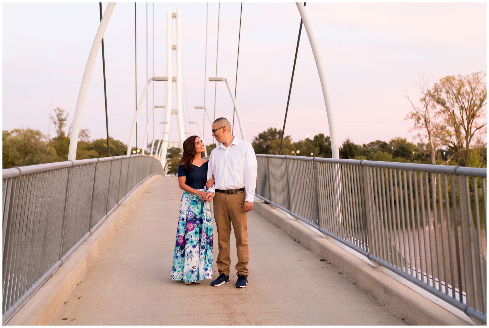 bride and groom walk hand in hand on IPFW bridge in Fort Wayne Indiana