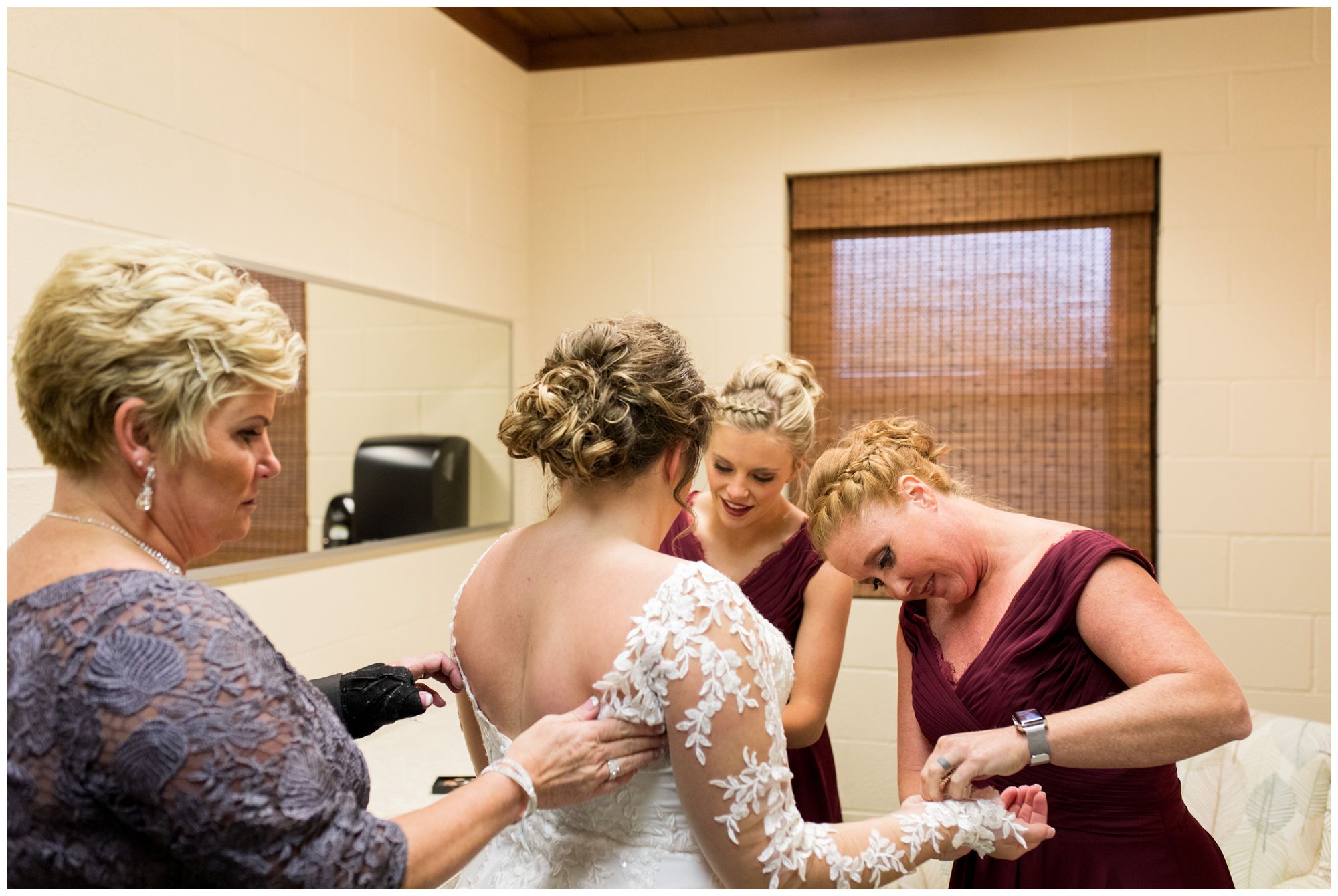 bridesmaids and mom help bride into dress at Zion Lutheran Church in Decatur