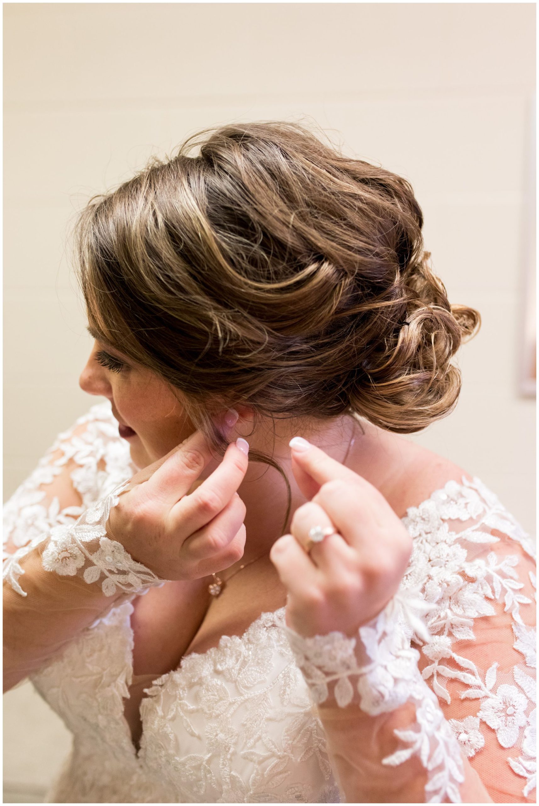 bride puts on earrings before wedding ceremony