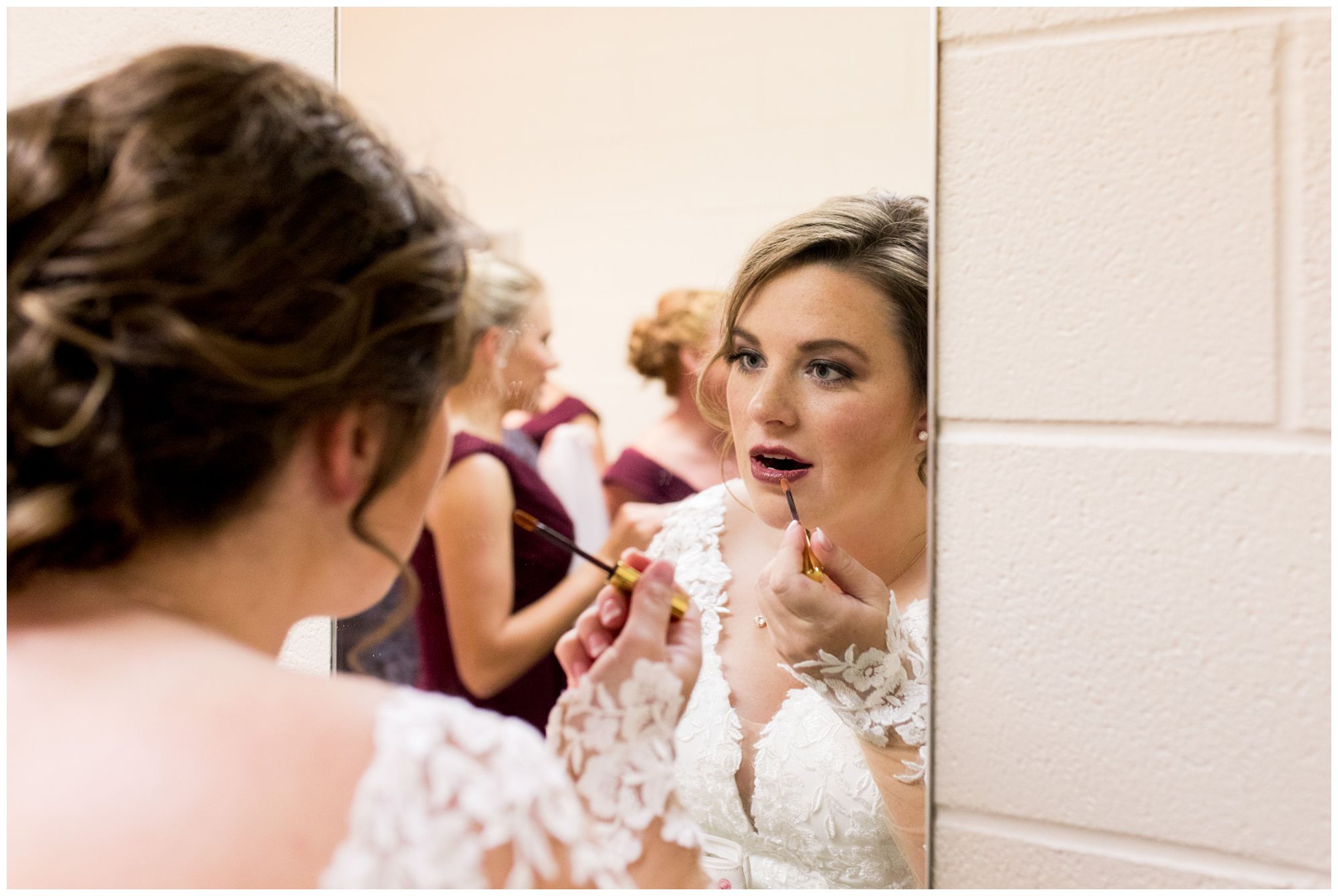 bride applies lipstick before first look with groom at Zion Lutheran Church