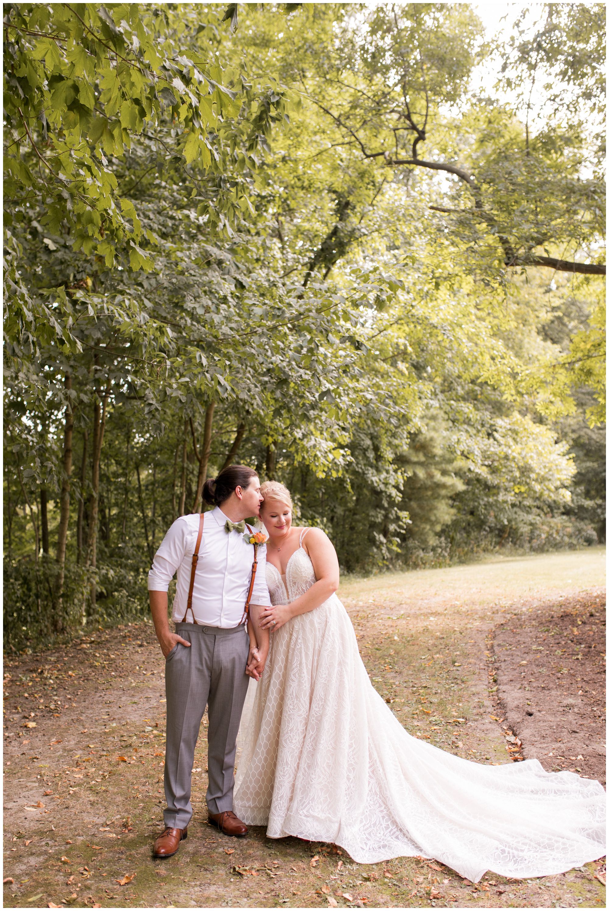 groom kisses side of bride's head at Forest Park Inn in Noblesville