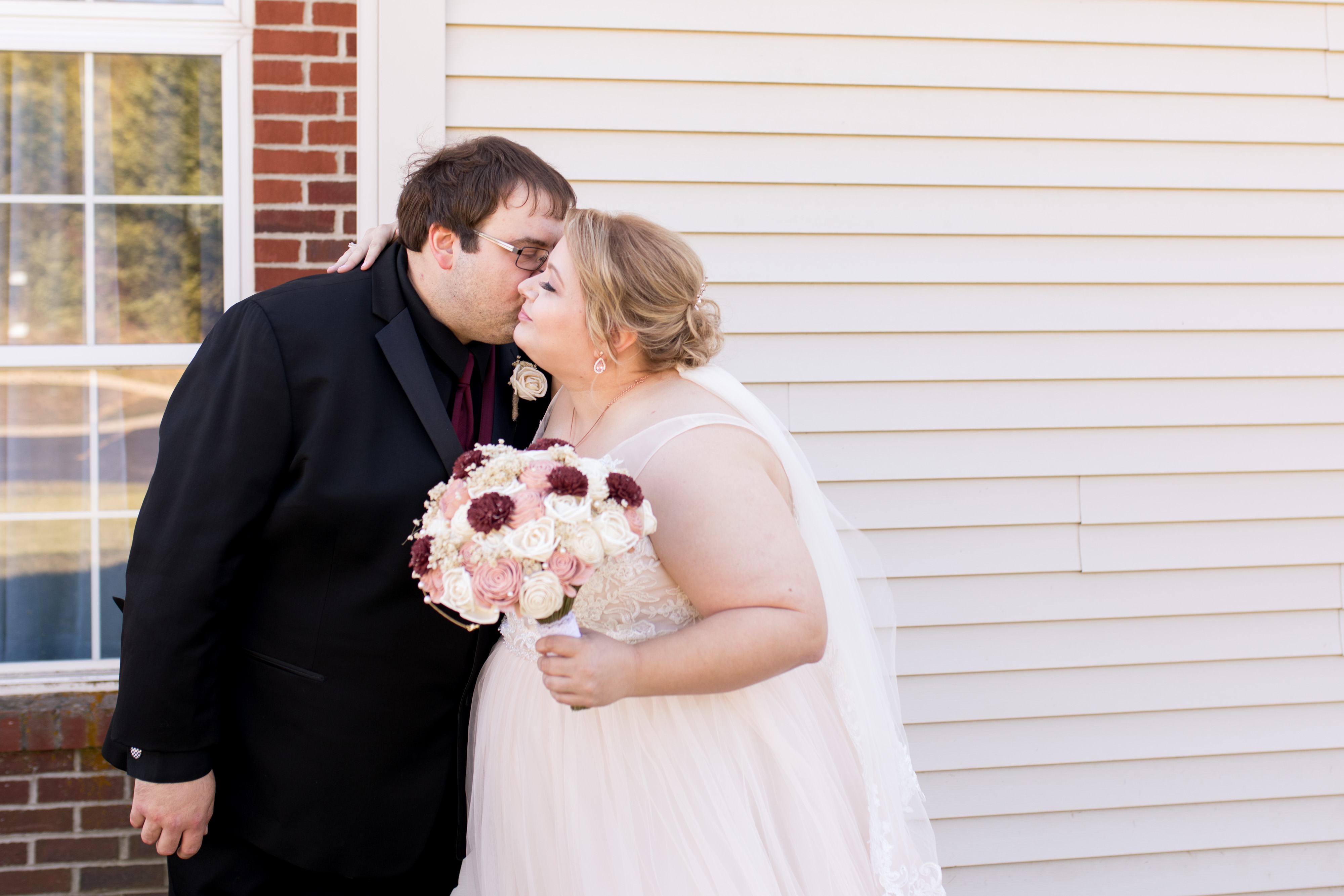 groom kisses bride's cheek during first look before wedding in Kokomo Indiana