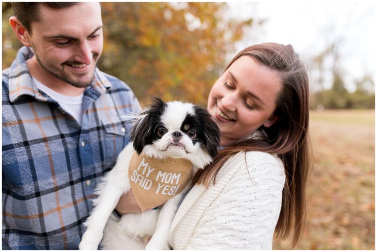 bride and groom hold dog during engagement session at Jackson Morrow Park in Kokomo Indiana
