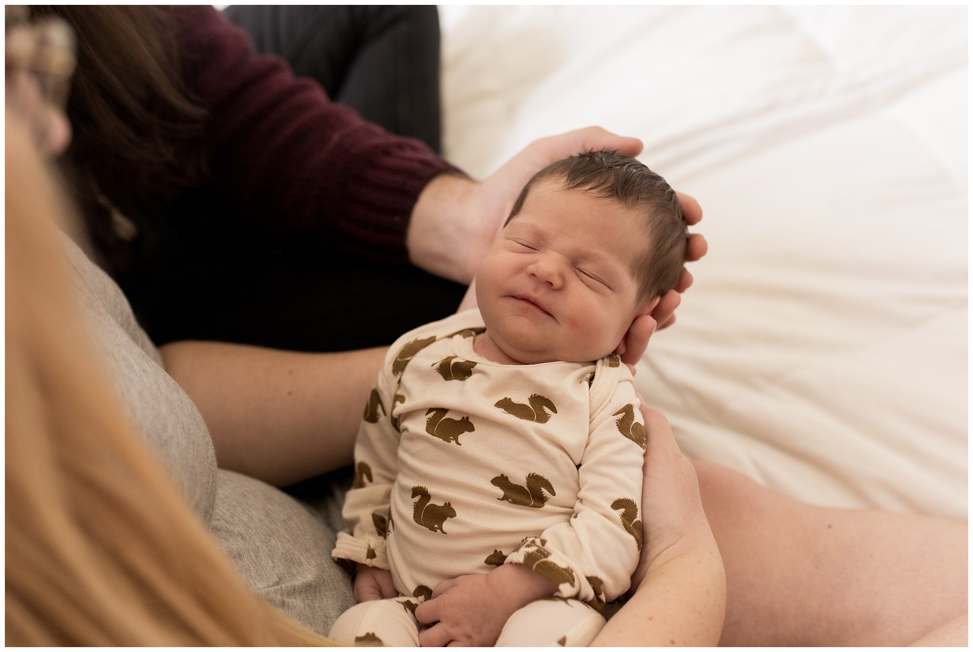 mom and dad hold baby together during Indianapolis newborn session