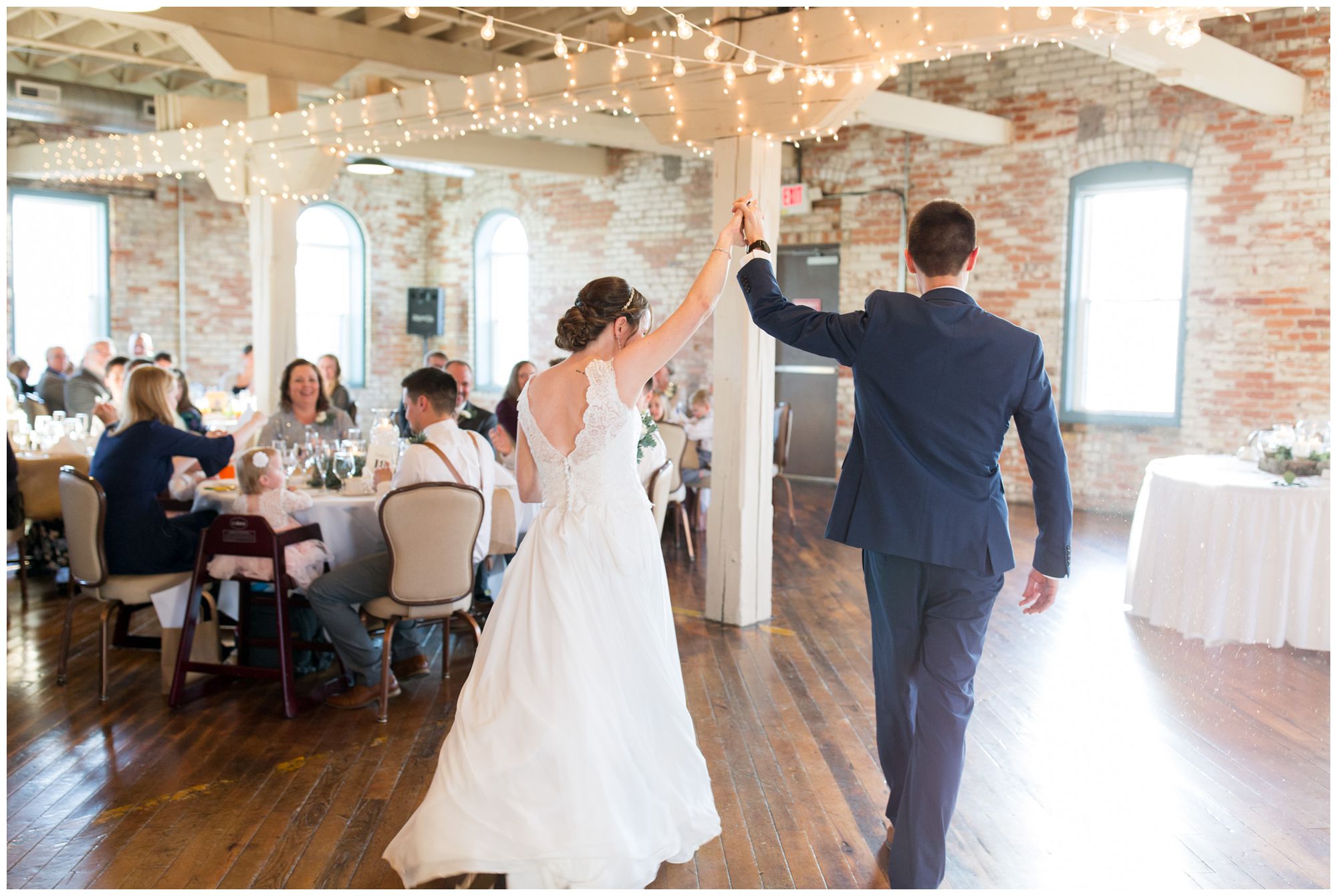 bride and groom walk into Bread & Chocolate wedding reception holding hands