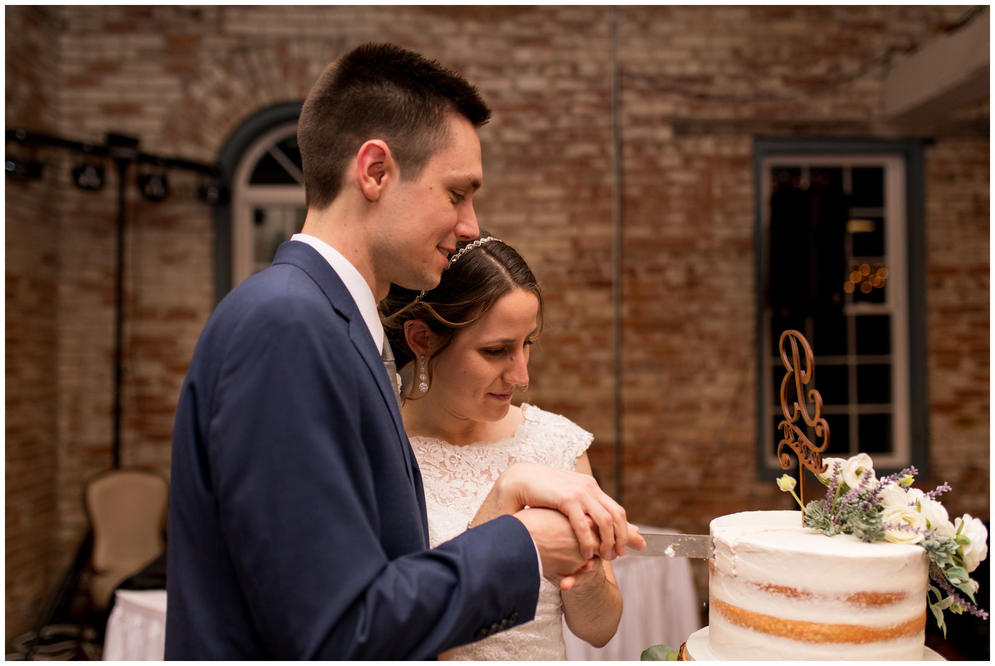 bride and groom cut wedding cake together
