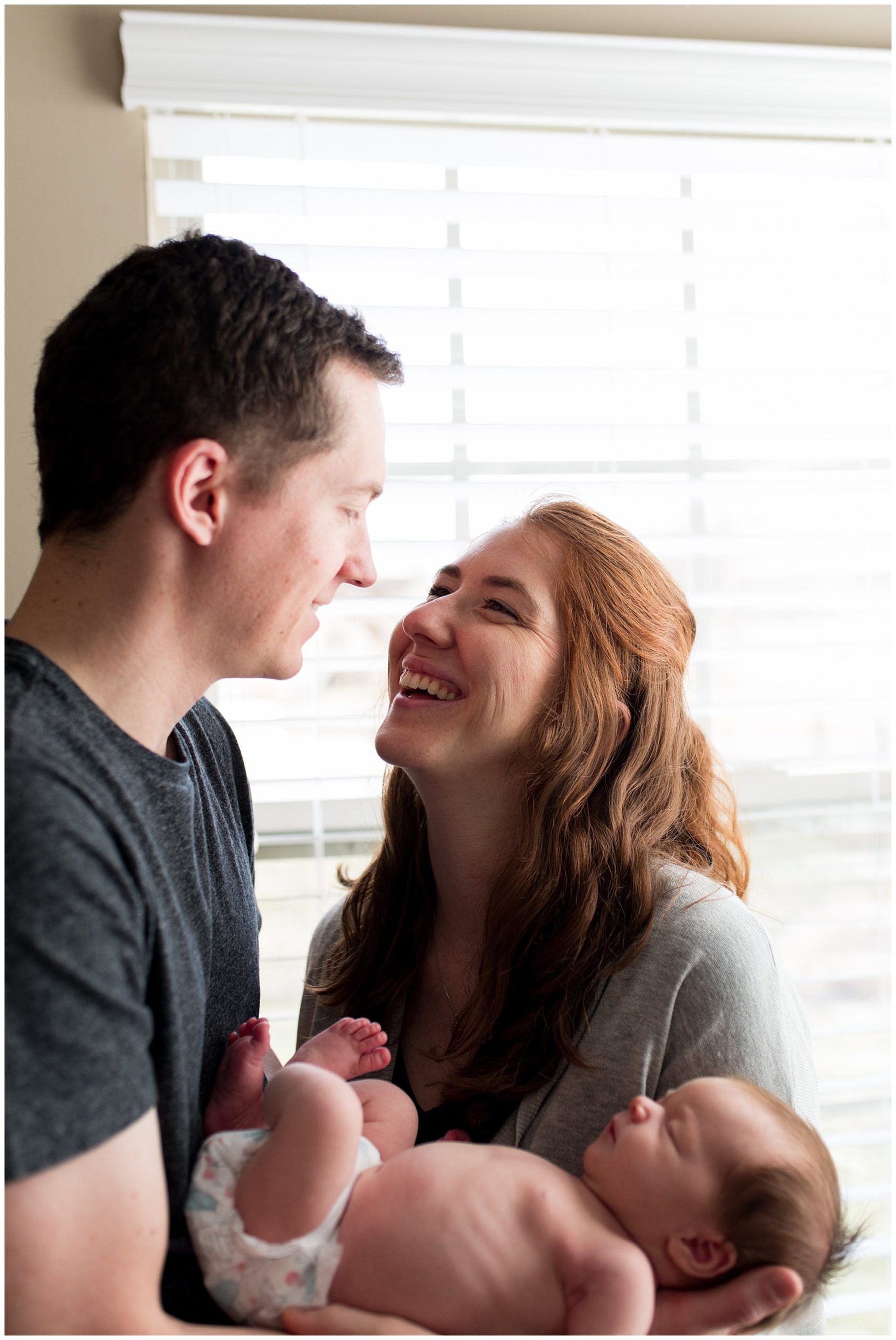 mom smiles up at dad during newborn session in Columbus Indiana