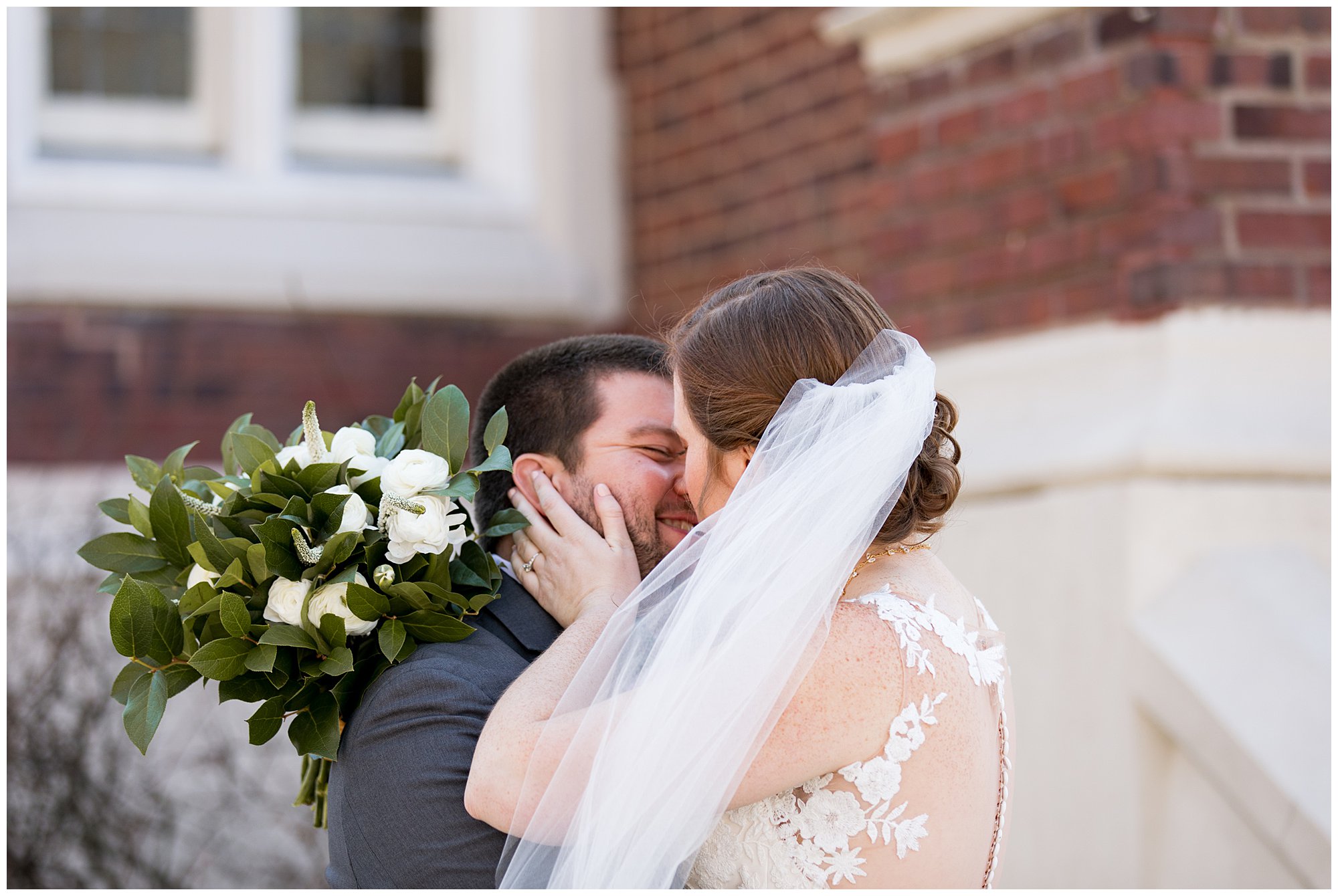 bride and groom kiss after first look outside of church
