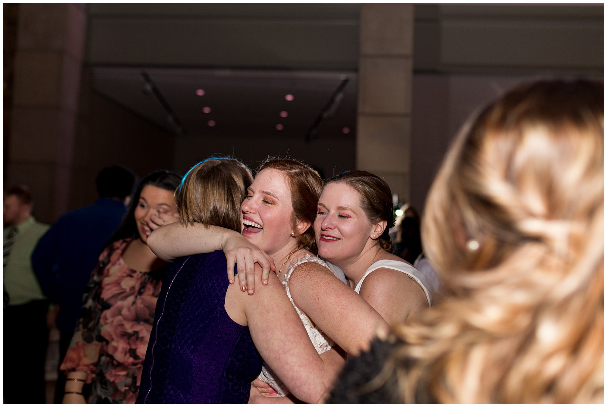 bride hugs wedding guests on dance floor
