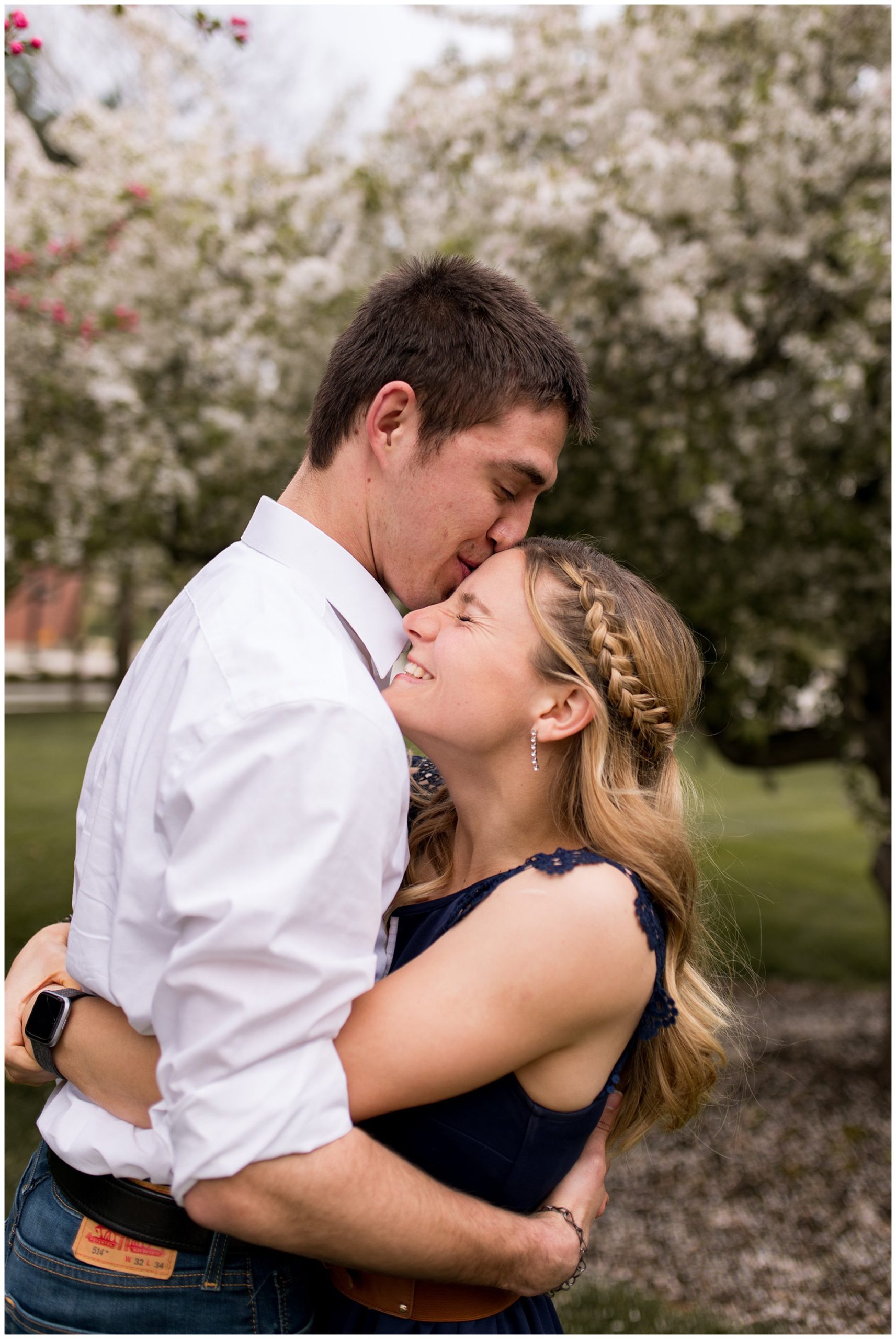 groom kisses bride's head during engagement photos at Purdue University