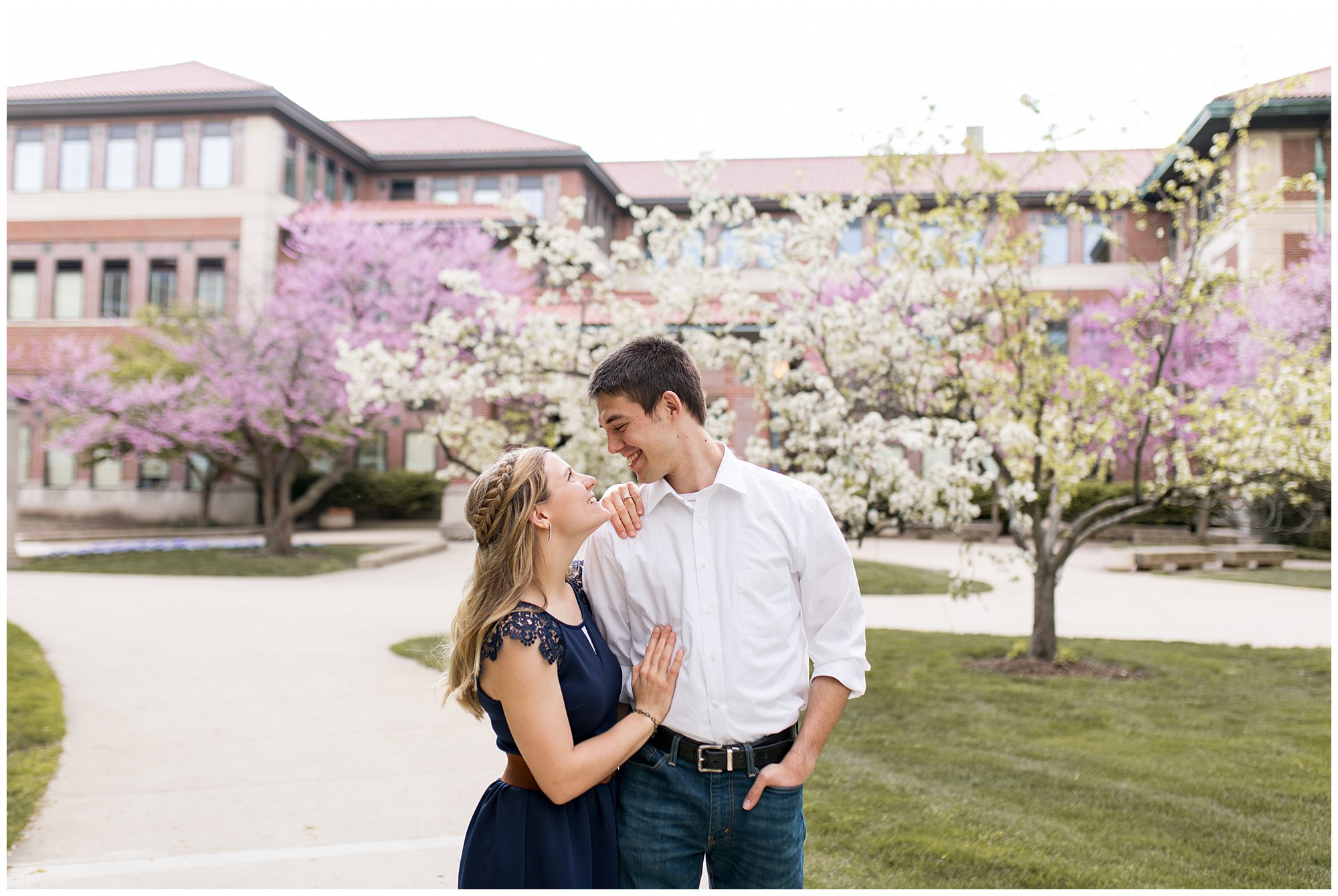 bride and groom look into each other's eyes in front of flowering trees at Purdue