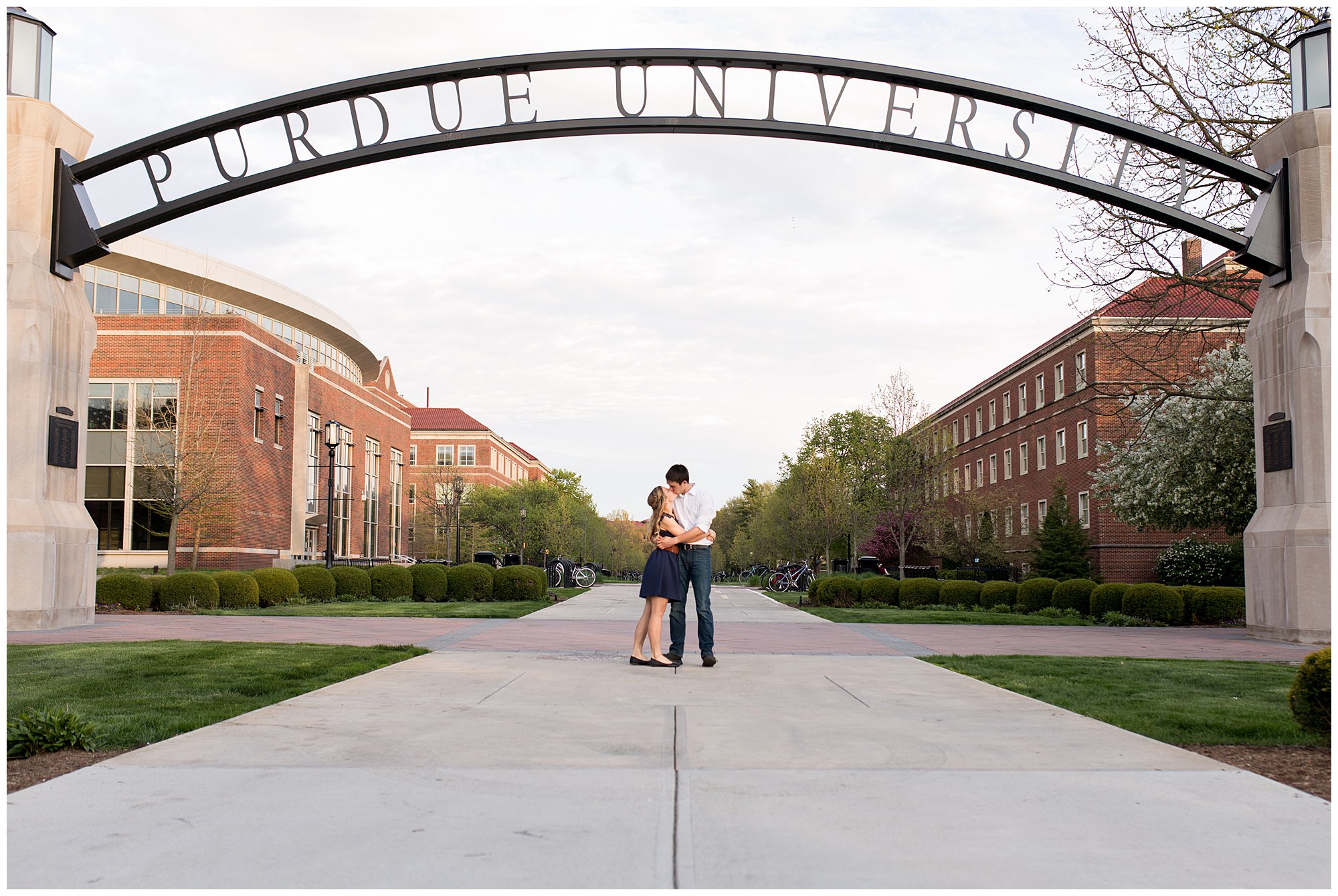 bride and groom kiss under Purdue University arch