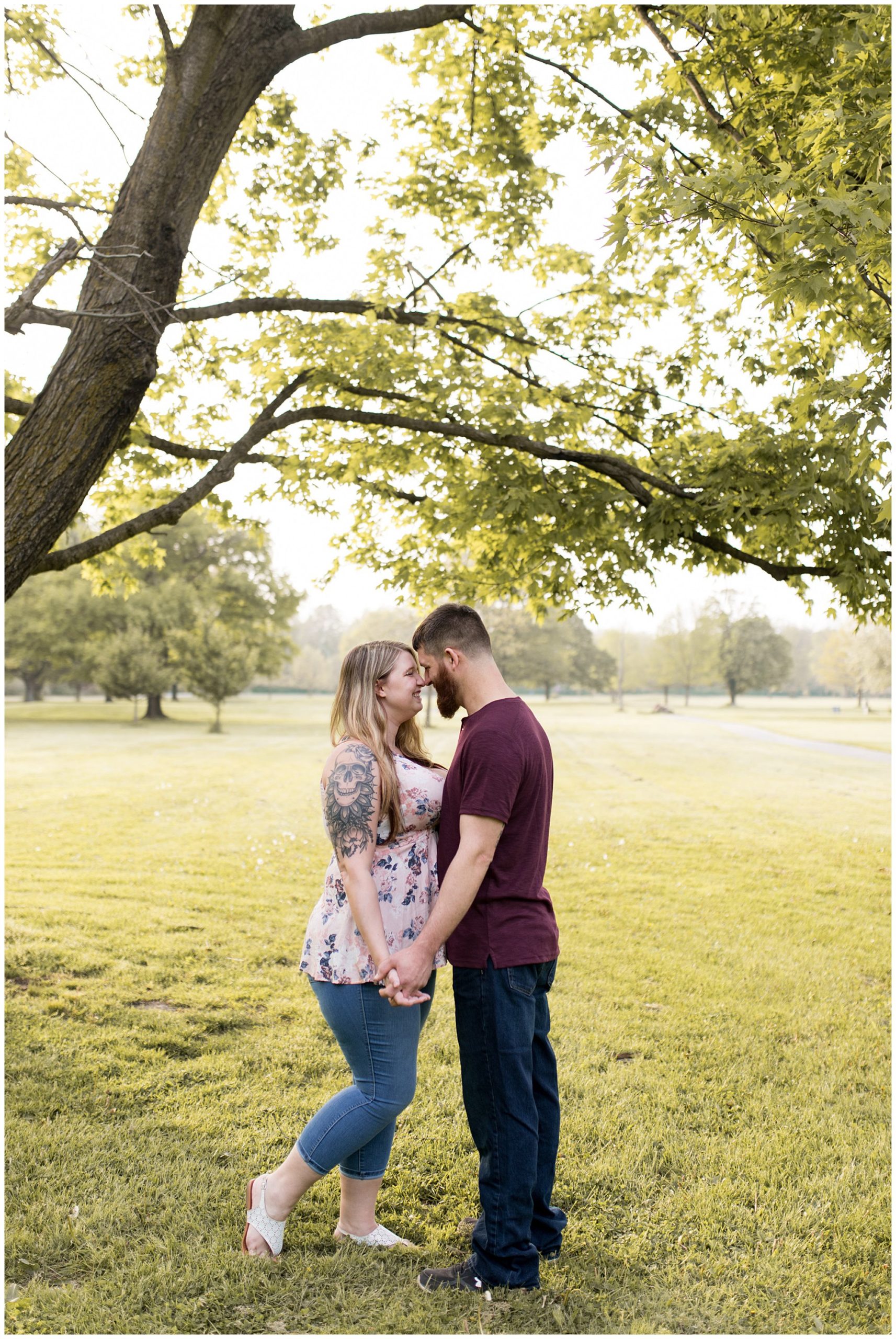 couple holds hands during Fort Wayne engagement session at Foster Park