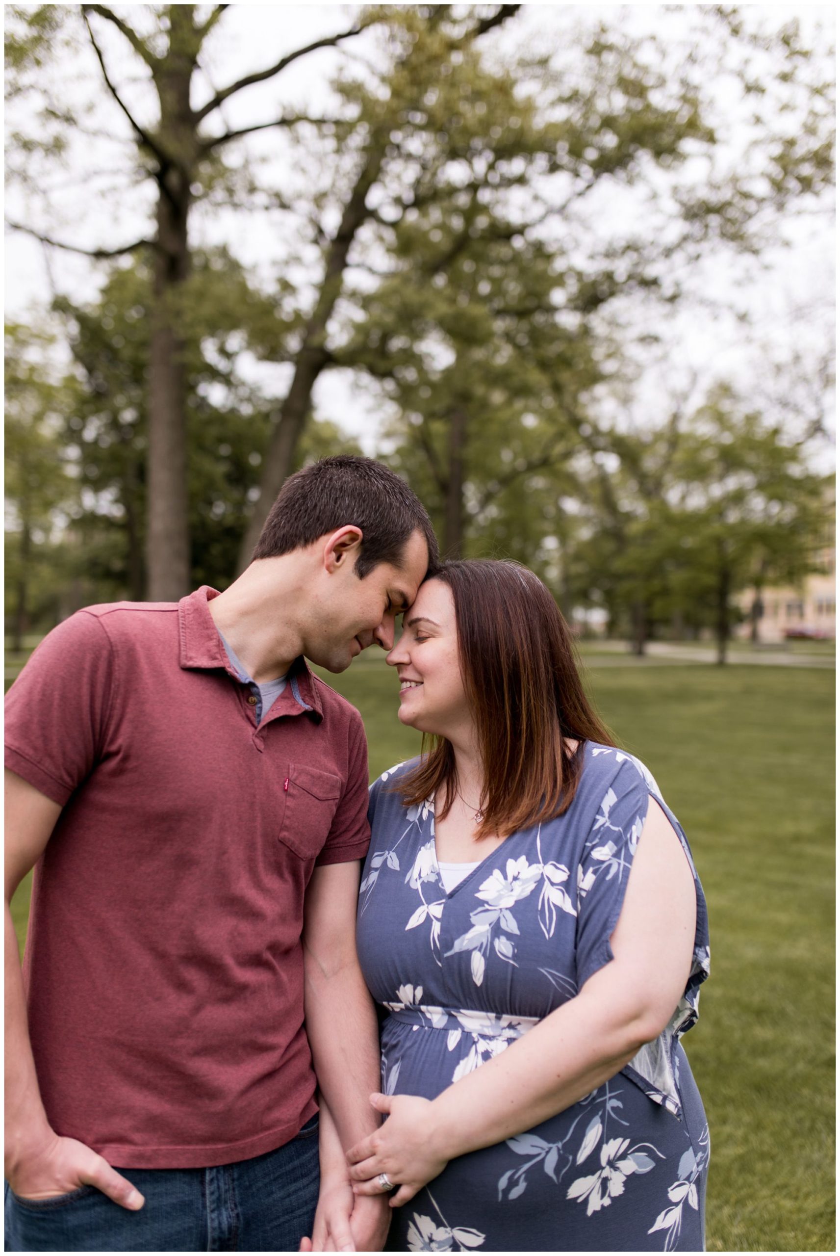 mom and dad hold hands during maternity session at Ball State University