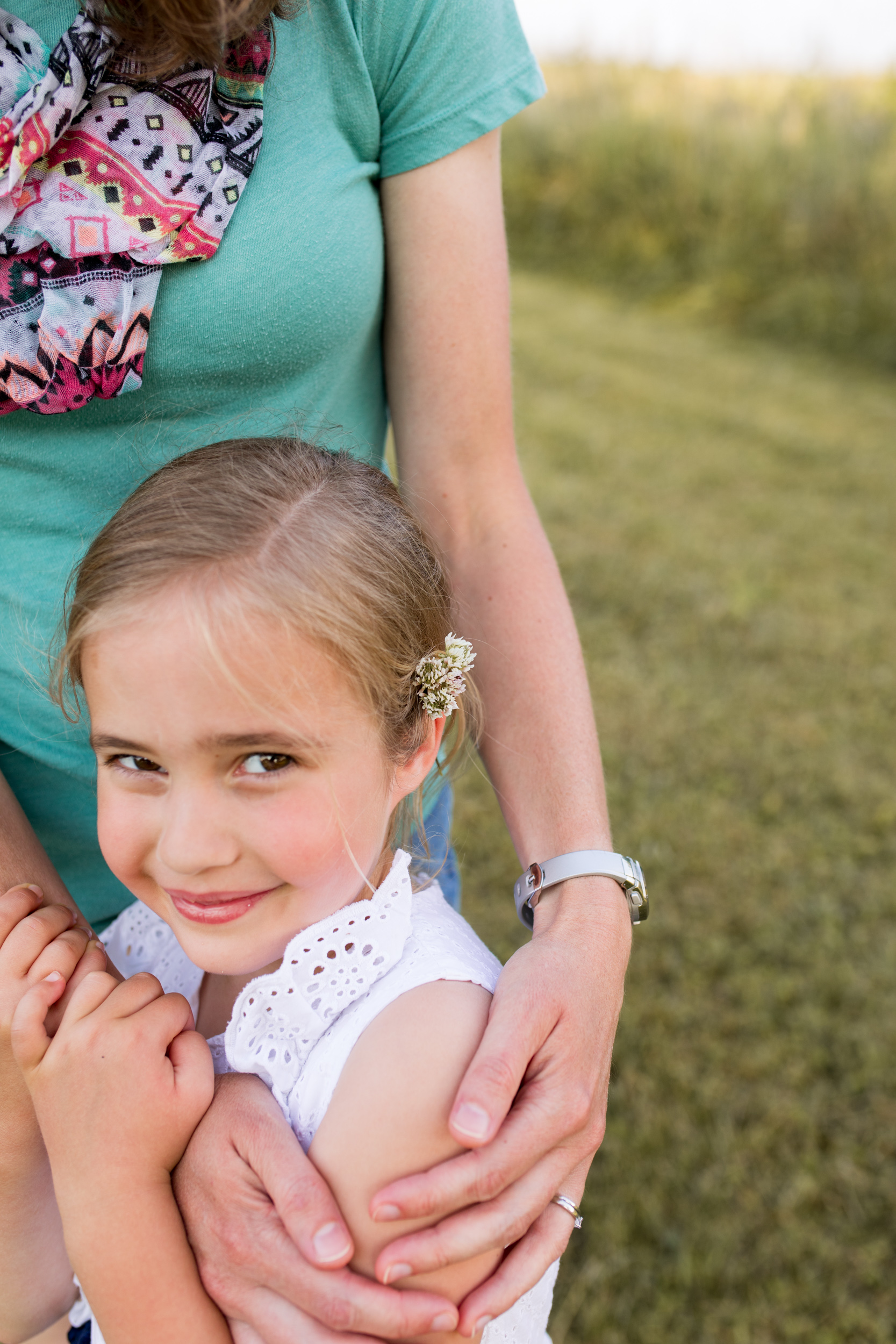 mom places flowers in daughter's hair