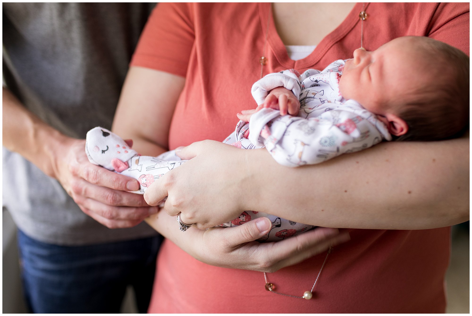 newborn baby in mom and dad's arms at in-home newborn session