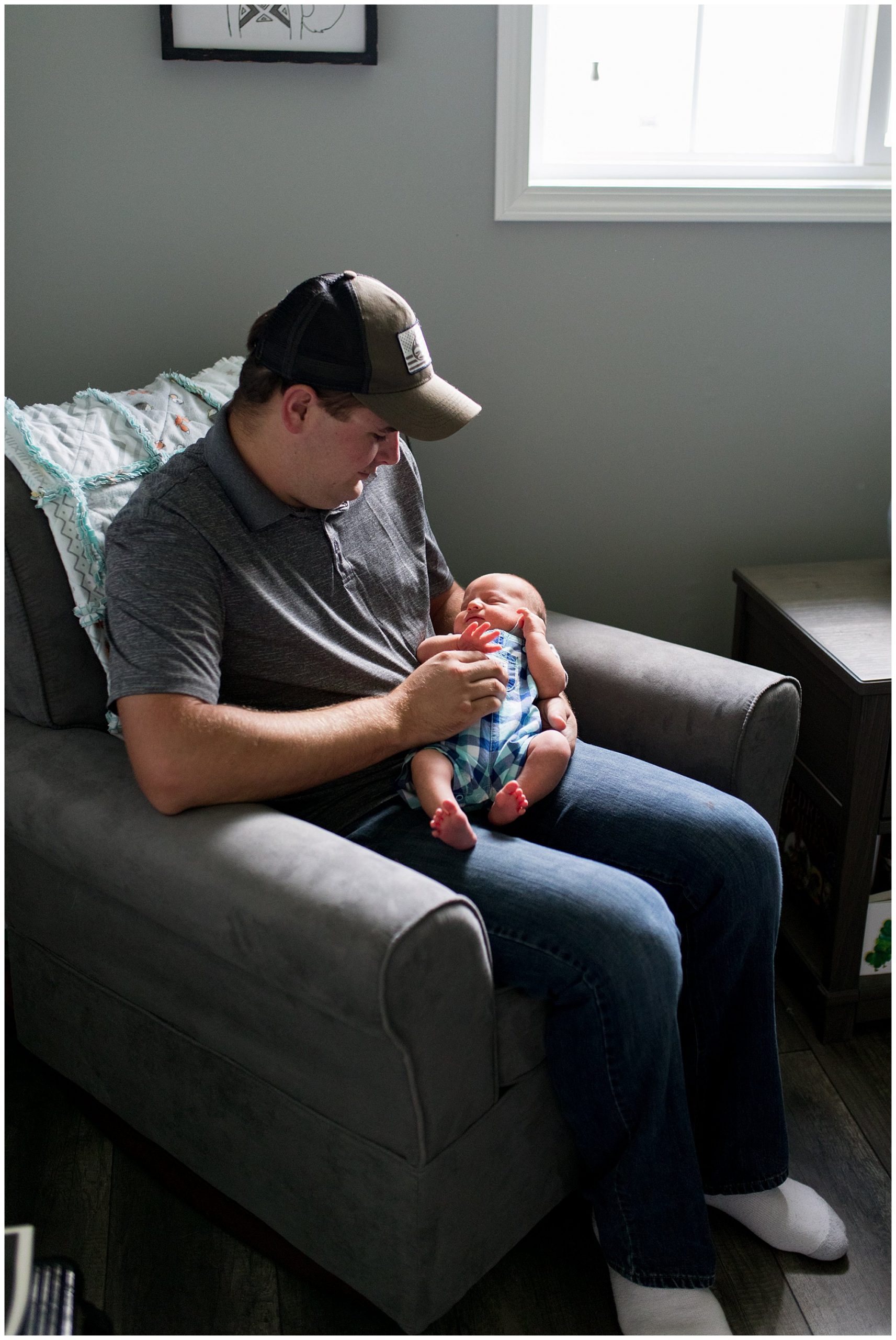 dad holds newborn baby during in home session in Muncie Indiana