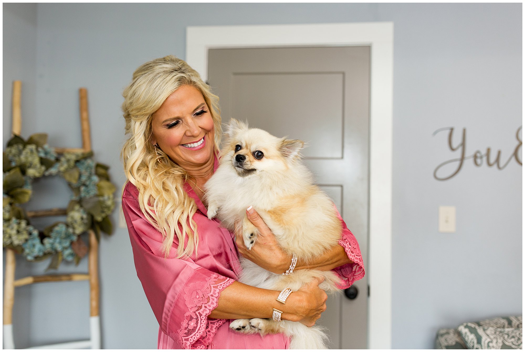 bride's mom holds bride's dog while getting ready