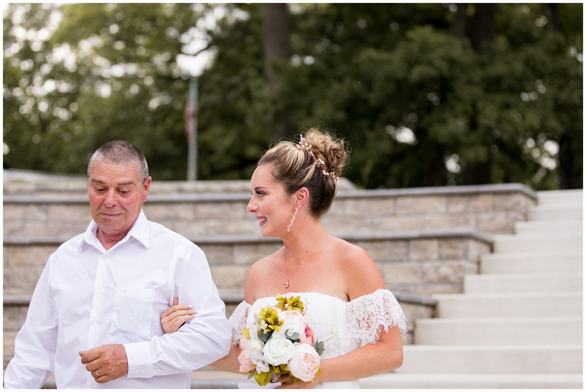 bride walks down steps with father during wedding ceremony in Warsaw Indiana