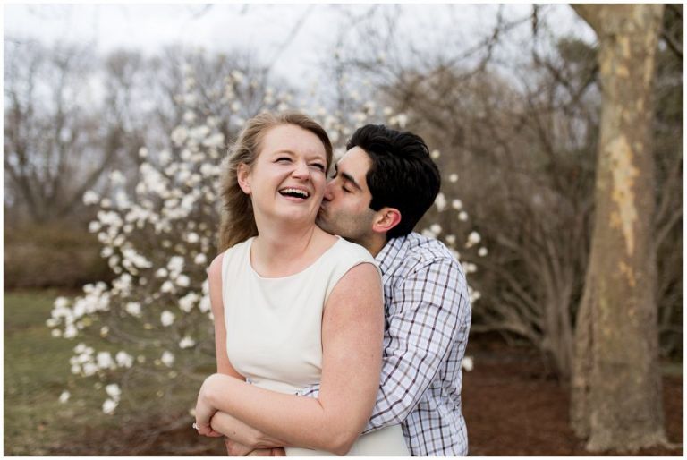 groom kisses bride's cheek during Headwaters Park engagement session in Fort Wayne